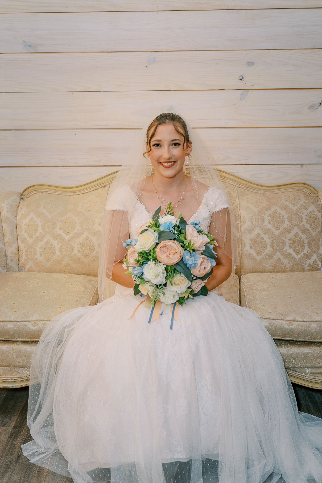 A bridal portrait series showing the flowing tulle skirt of a white wedding gown against a rustic wooden backdrop.