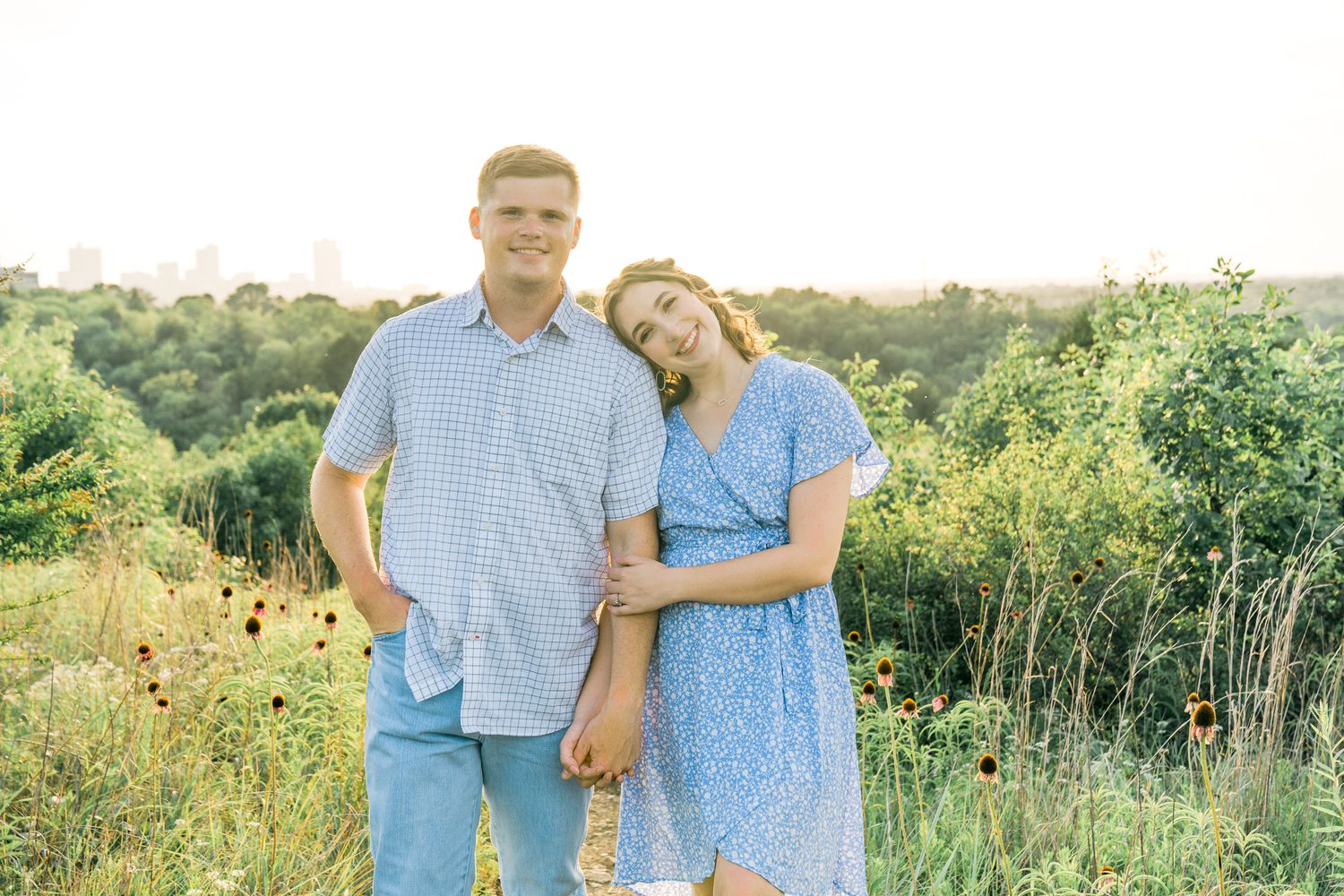 Romantic couple shares tender moments in a golden summer field with wildflowers at sunset.