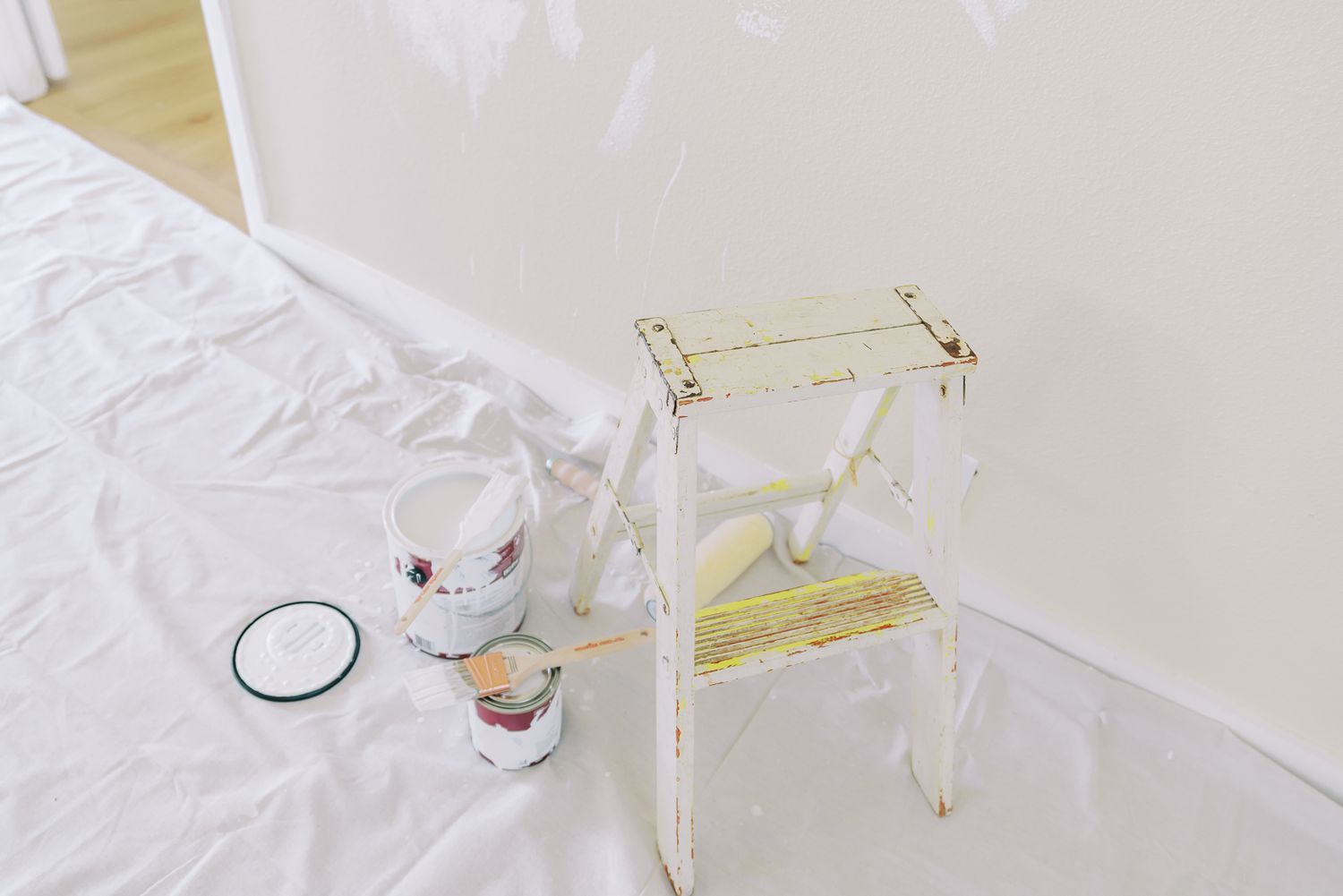 Minimalist white room interior with natural lighting streaming through windows.