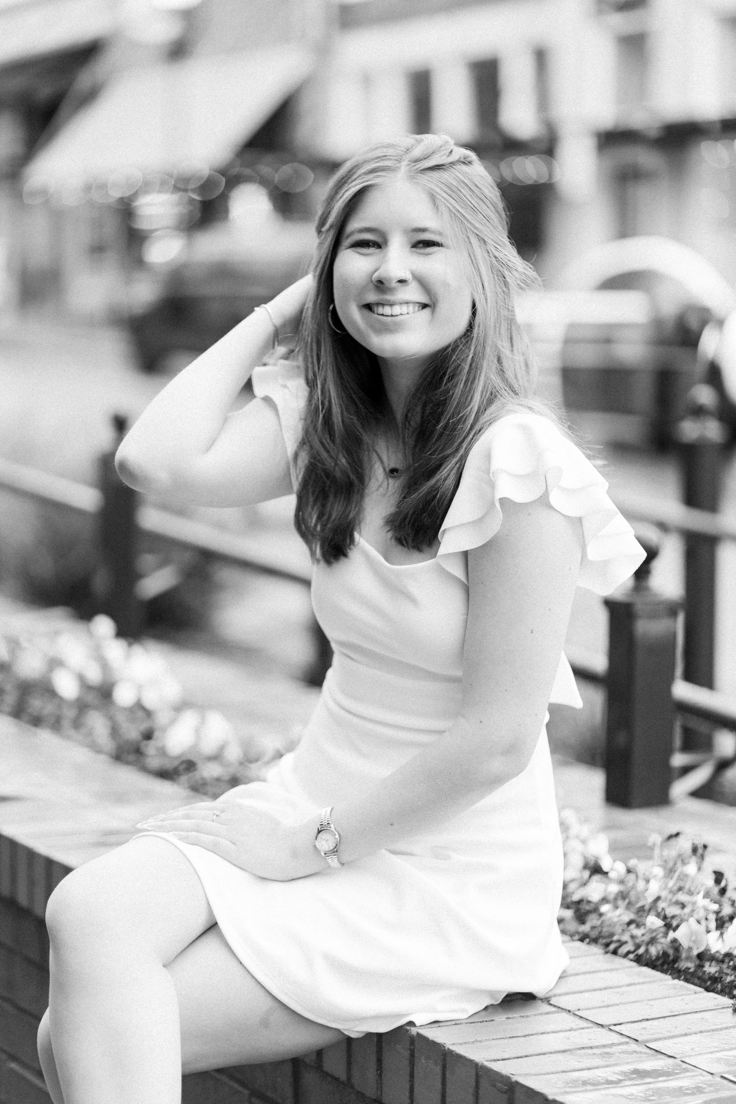 A collage of black and white photos showing a person in a white dress sitting outdoors on a bench with flowers nearby.