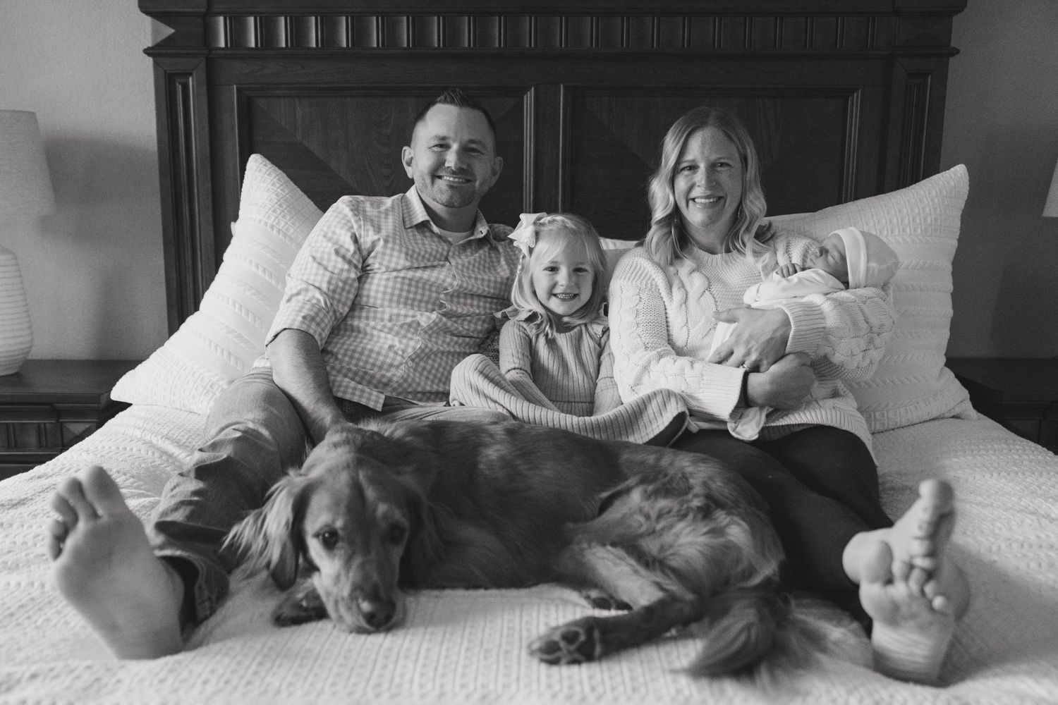 Black and white series of family and dog lounging together on bed showing different casual poses.