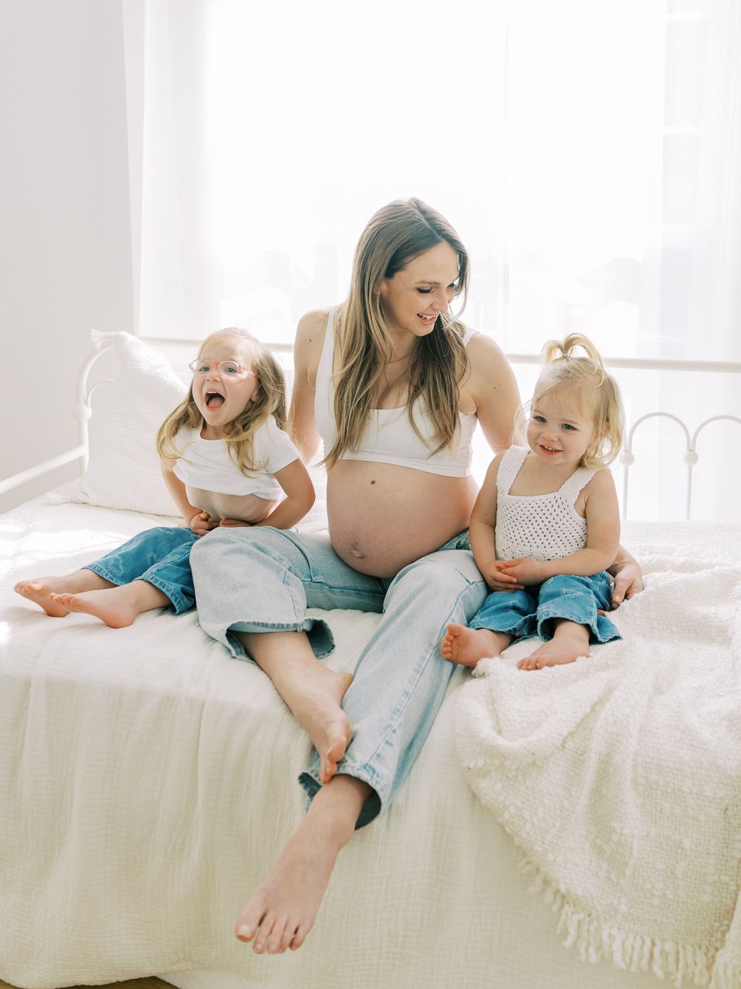 A series of five candid photos showing joyful moments between a mother and child playing together on a white bed.