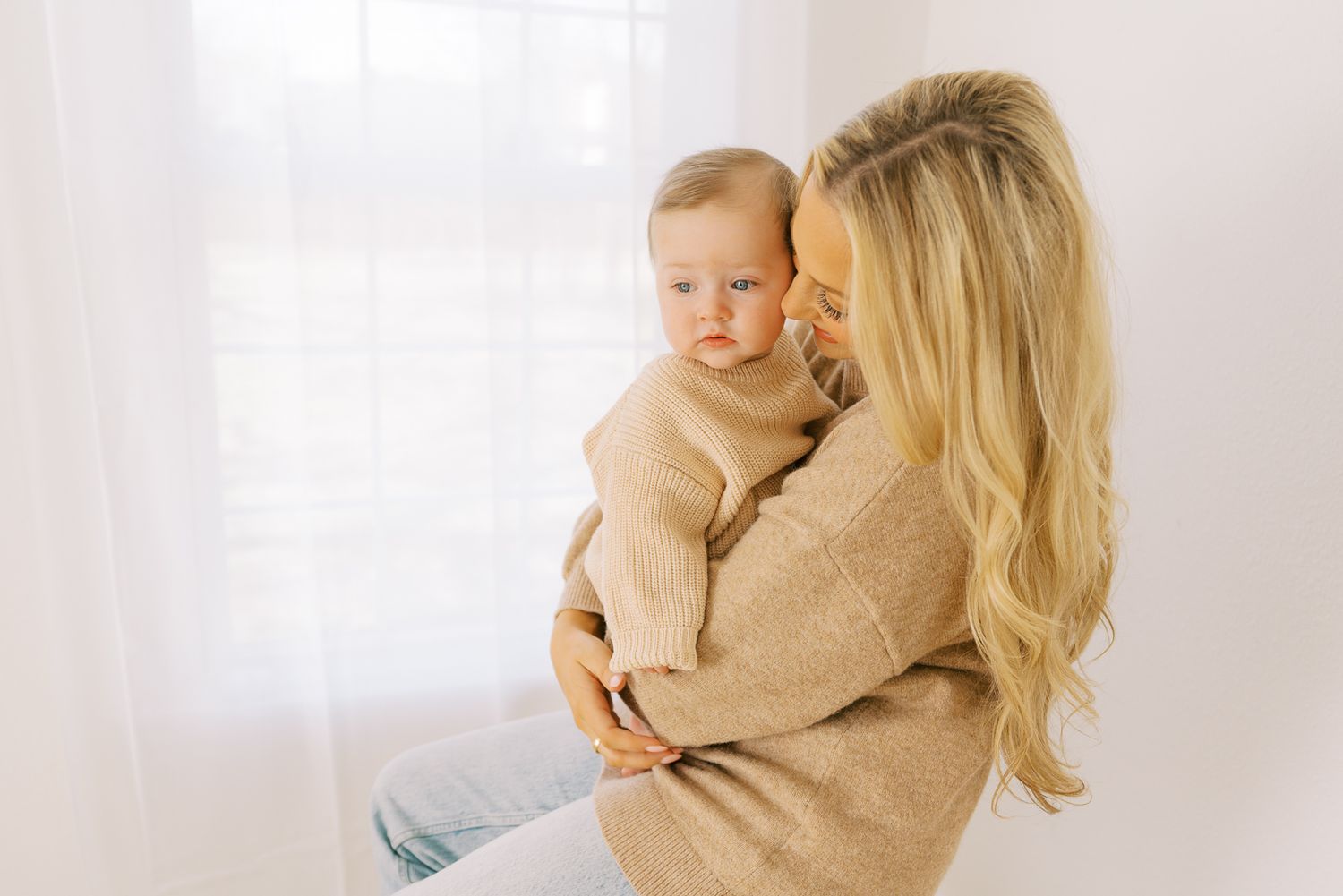 A series of tender moments between parent and child in a bright white studio setting.