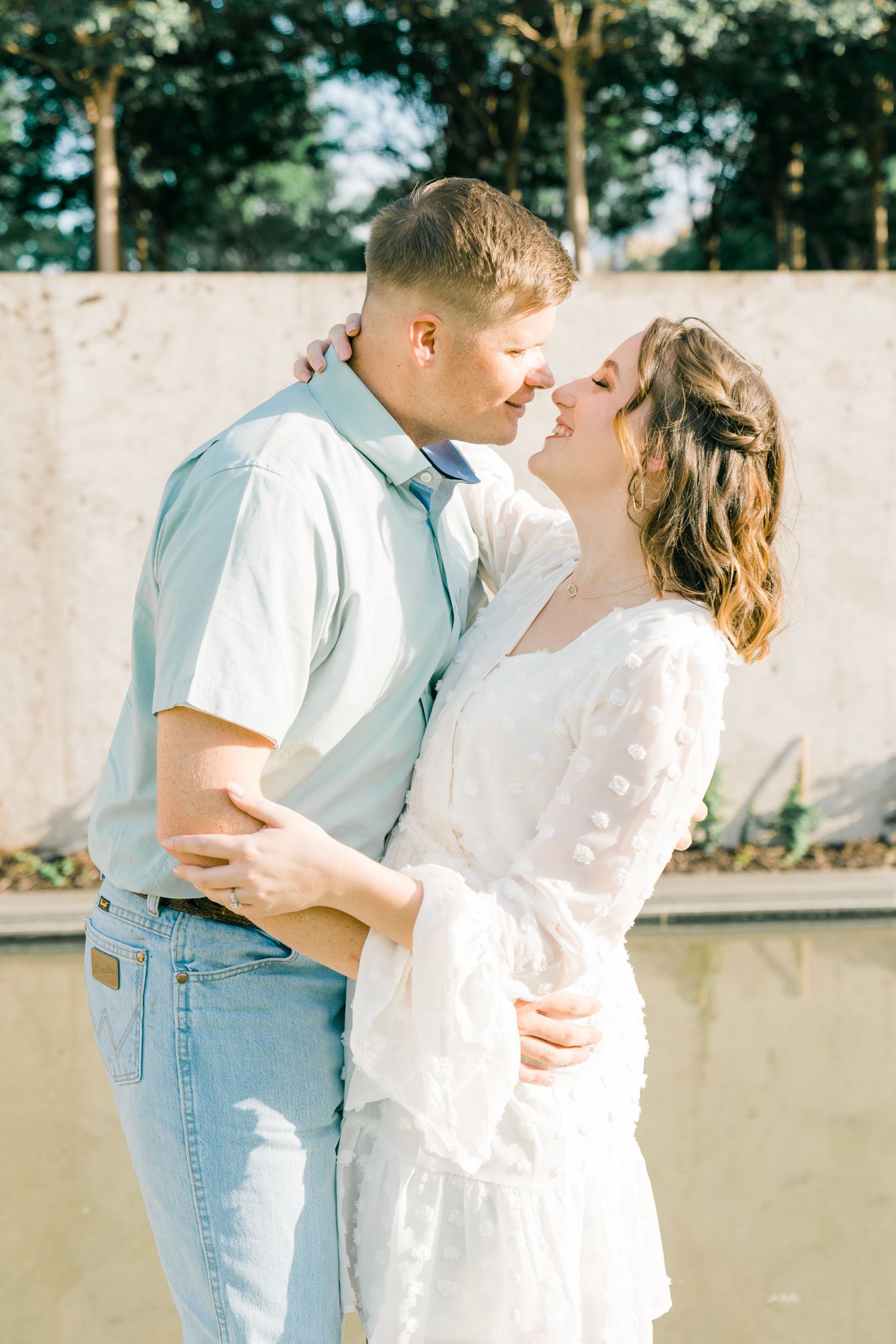 Intimate moment captured between couple in casual attire during outdoor photo session.
