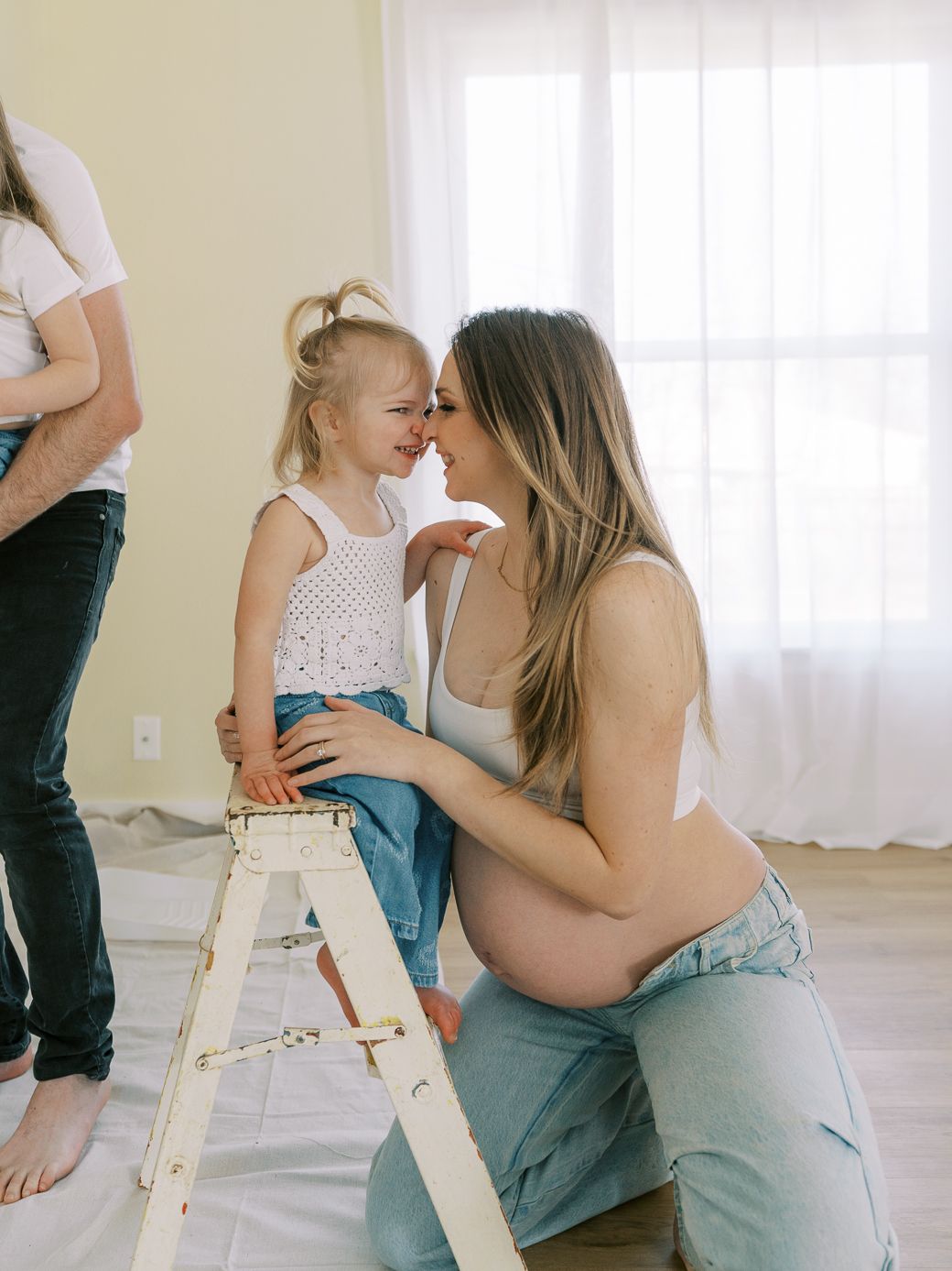 Family shares playful moments while working on home improvements in a sunlit room.