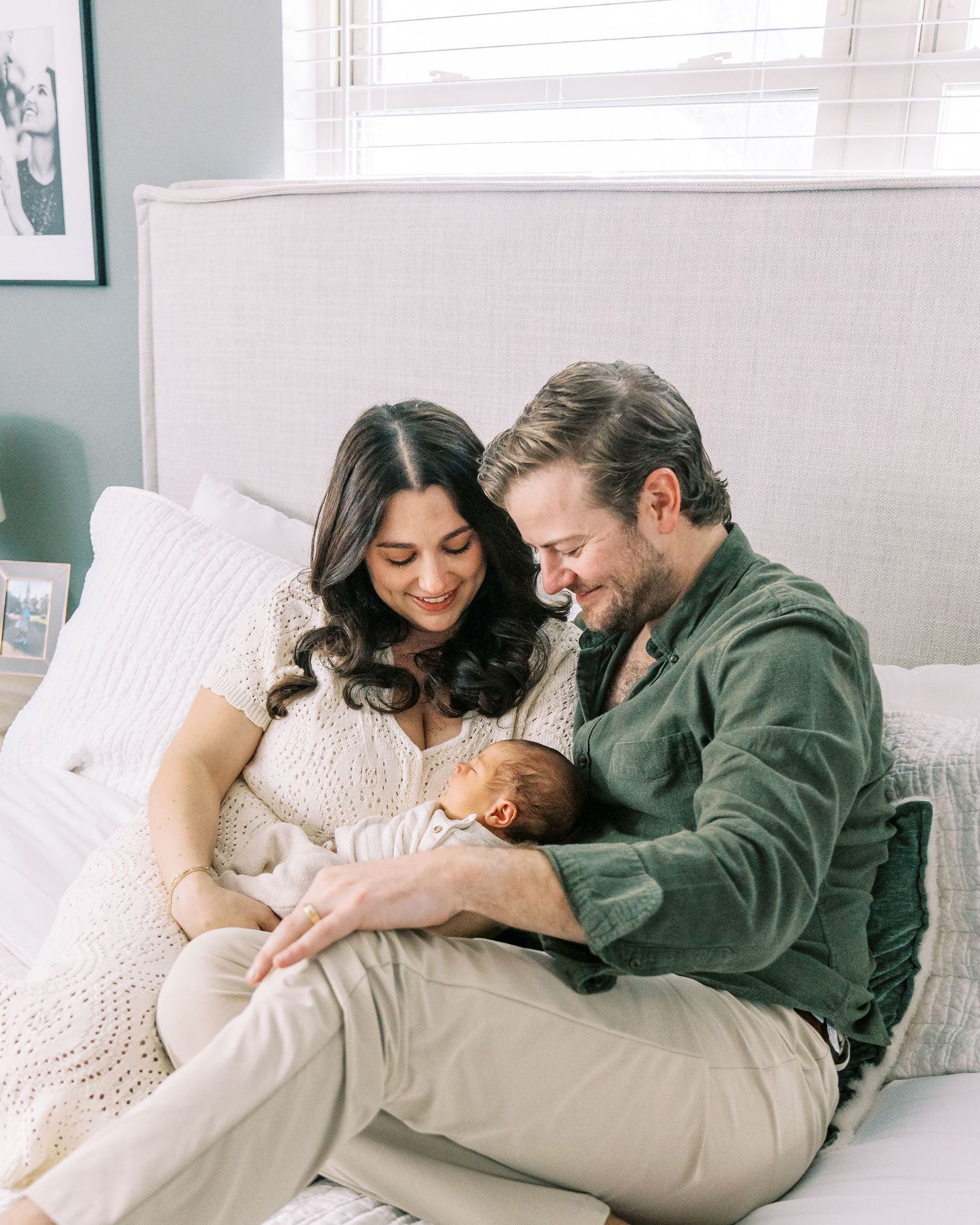 A couple lounges together on a couch in a bright room, sharing intimate moments across four similar photos.