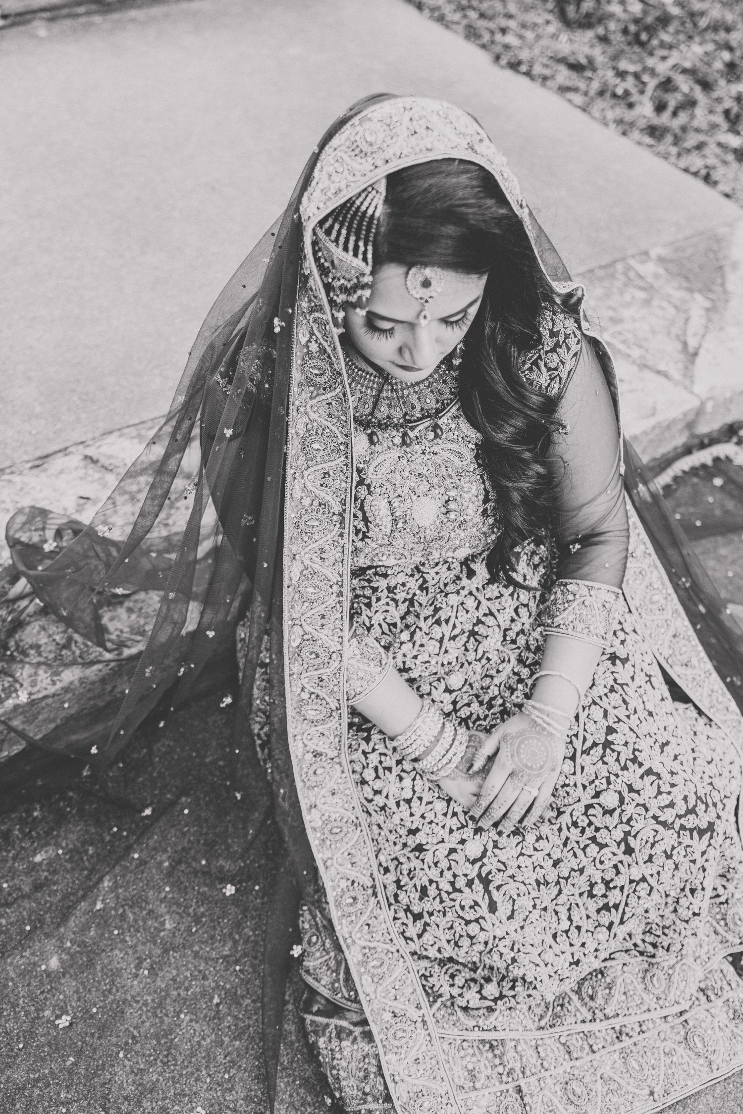 Overhead view of intricate embroidery details on a traditional bridal lehenga in black and white.