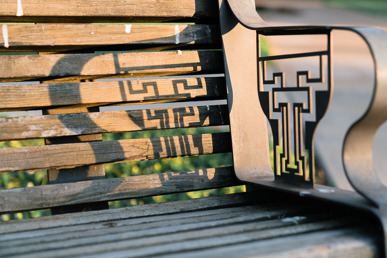 Wooden skateboard ramp with geometric patterns painted in black and white shows signs of wear from frequent use.