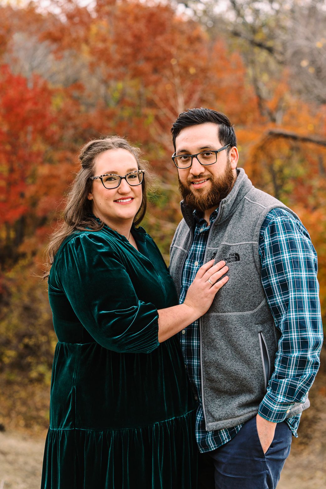 Couple shares romantic moments against vibrant autumn foliage backdrop in a series of candid outdoor photos.