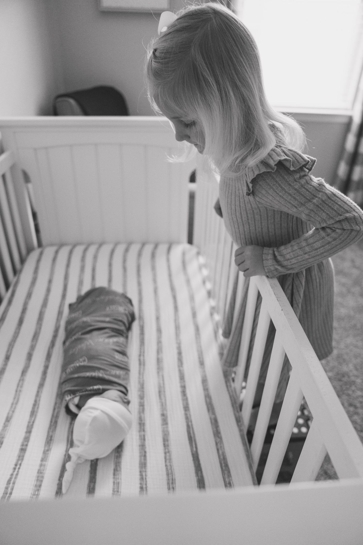 Black and white photo series showing a child in a sweater sitting at a white table from different angles.