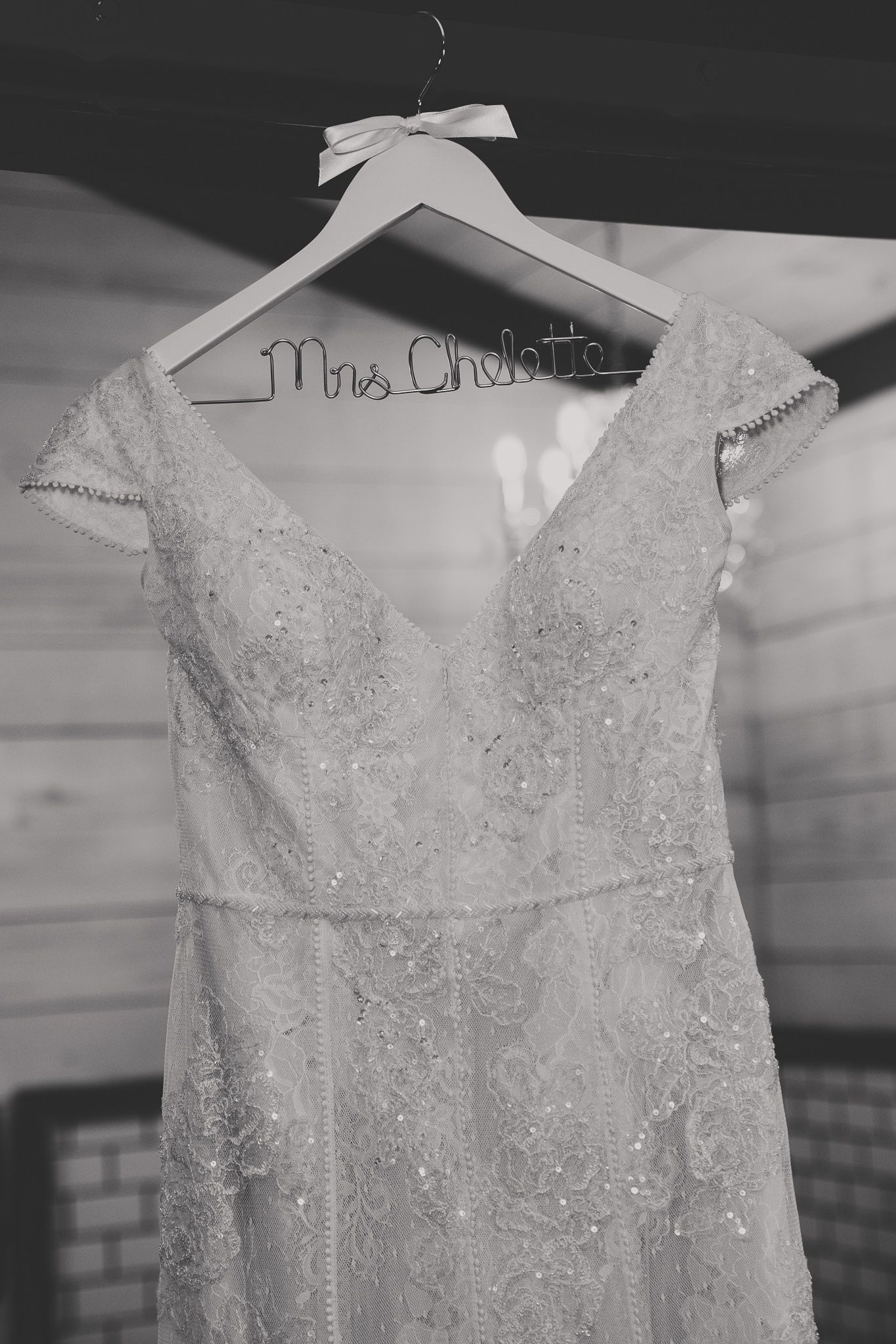 Close-up details of an elegant beaded white wedding dress bodice displayed on a hanger.