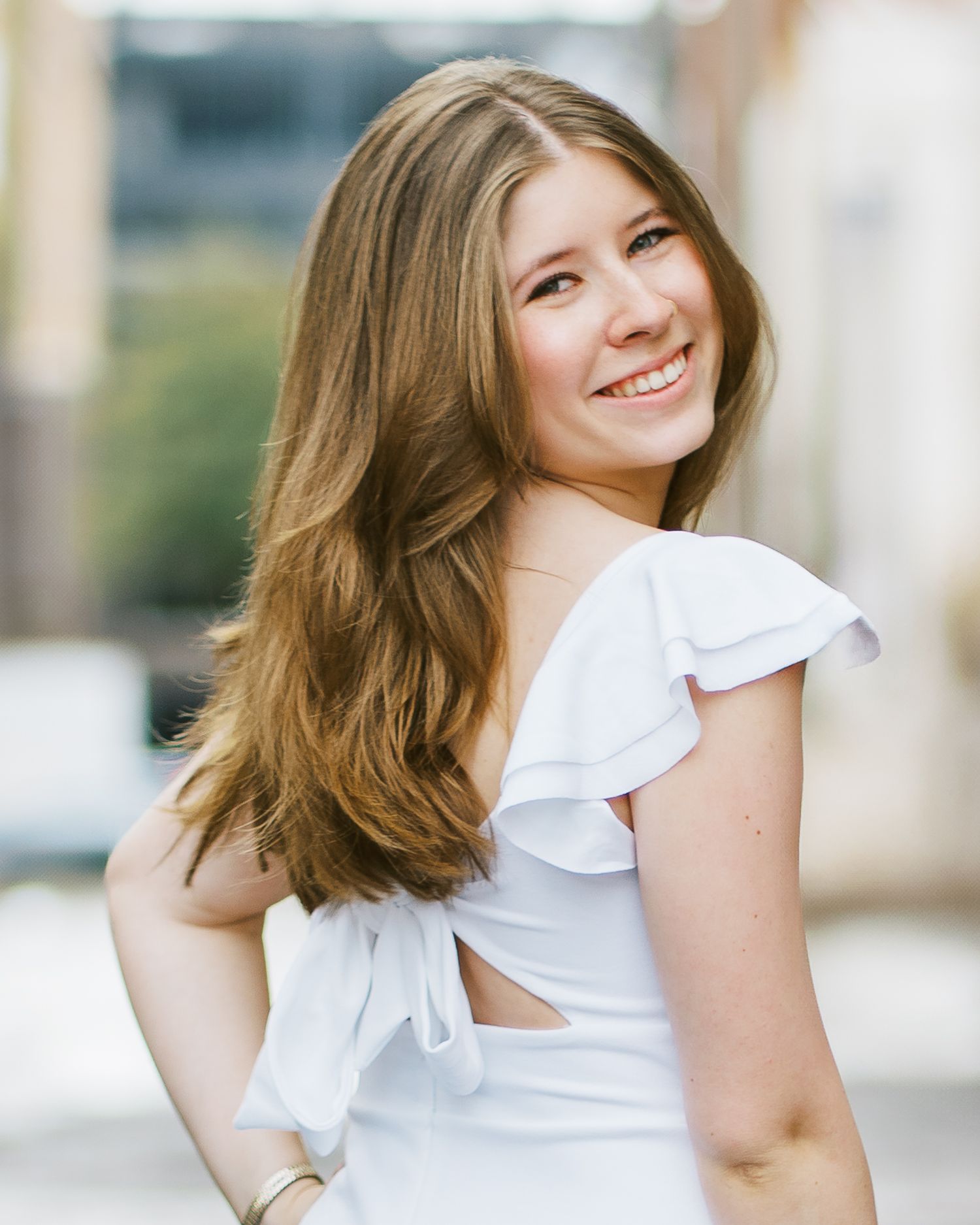 A person in a white ruffle sleeve top smiles while posing outdoors in a series of casual portrait shots.