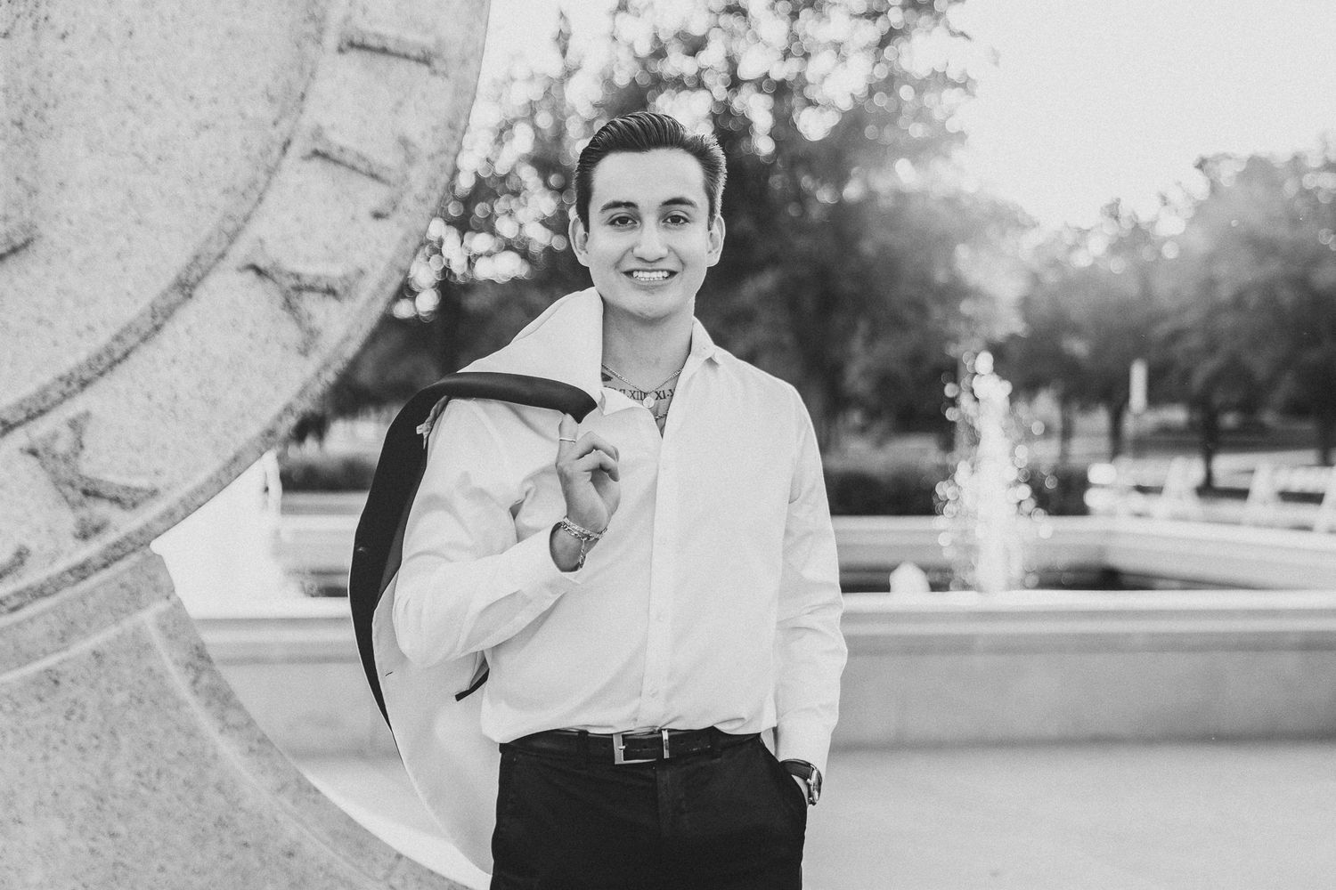 A black and white photo series showing someone in a white shirt posing and smiling outdoors.