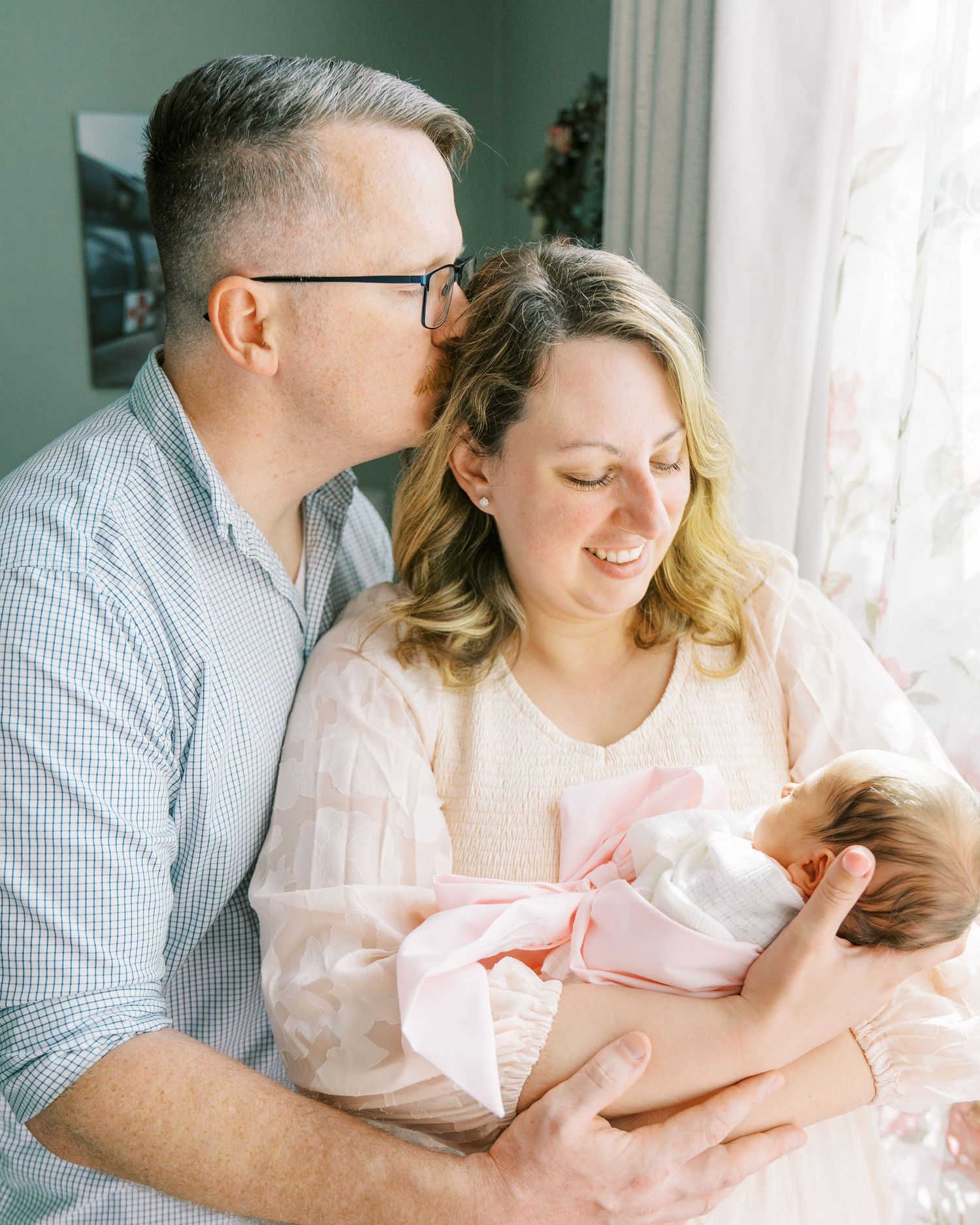 A tender family moment by a window with soft natural light streaming in.