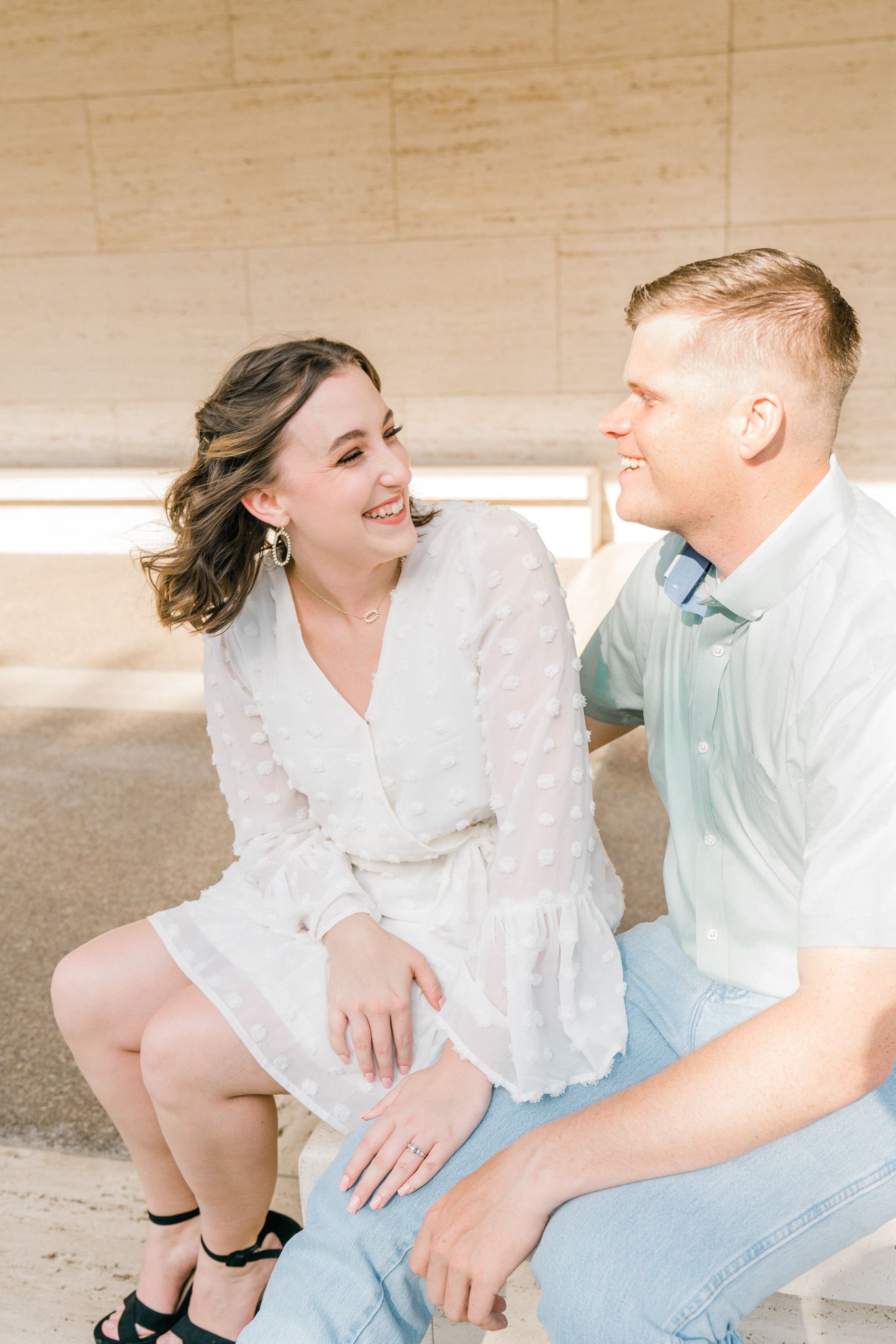 Couple in white and light blue outfits sharing intimate moments in a romantic outdoor photoshoot series.