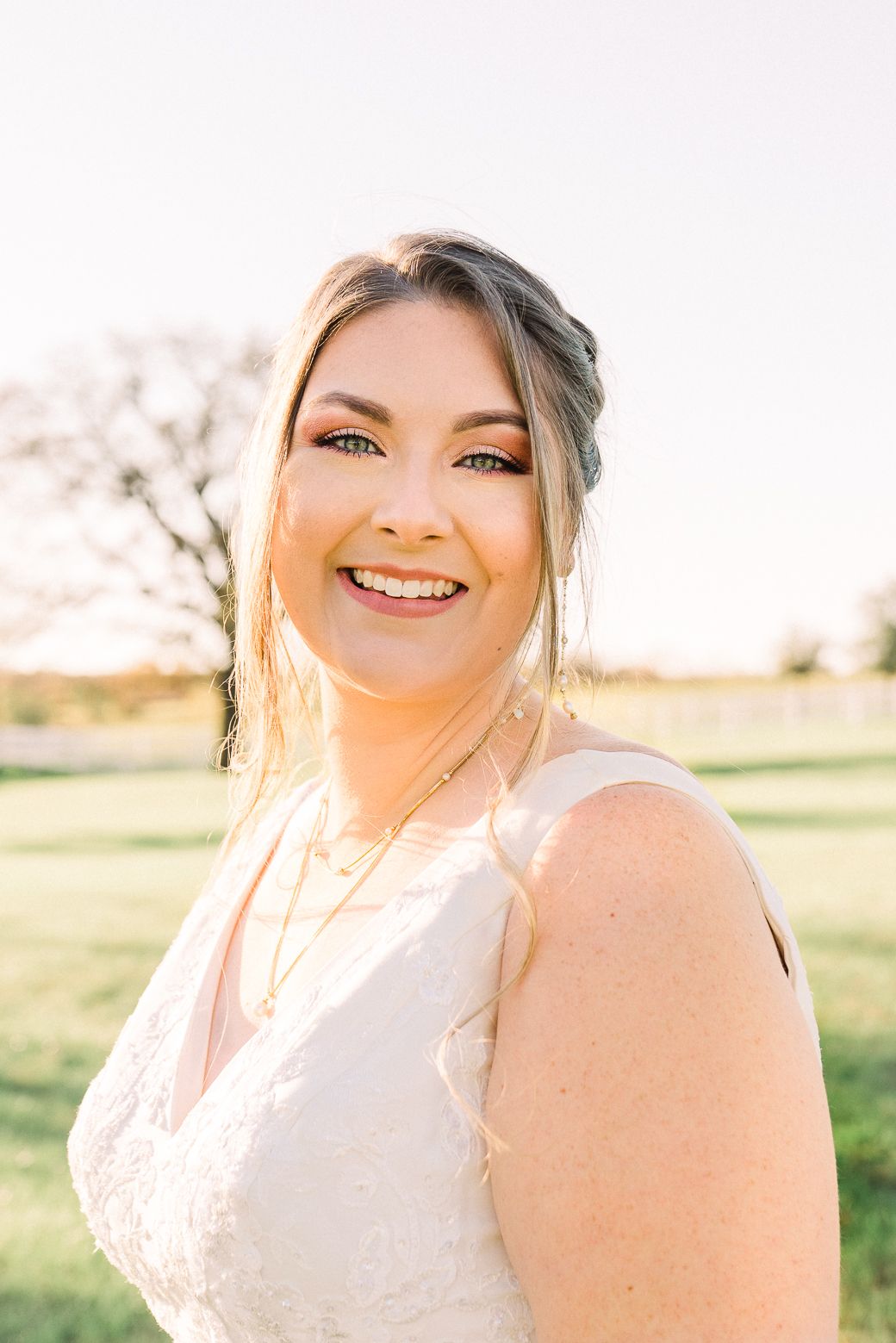 Bridal portrait in soft golden sunlight showing radiant joy and natural beauty.
