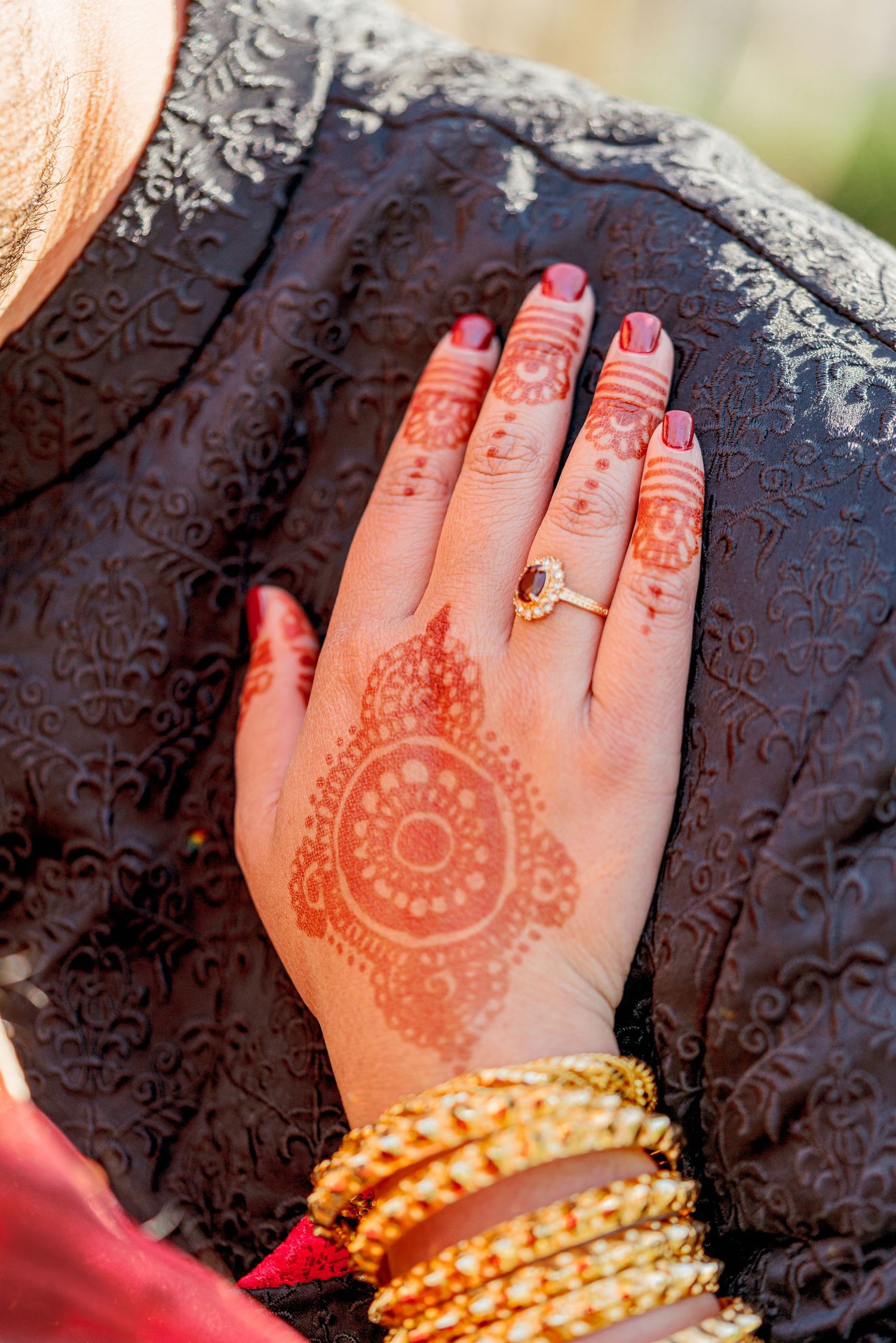 Close-up sequence of henna decorated hands with gold bangles on a dark textured background.