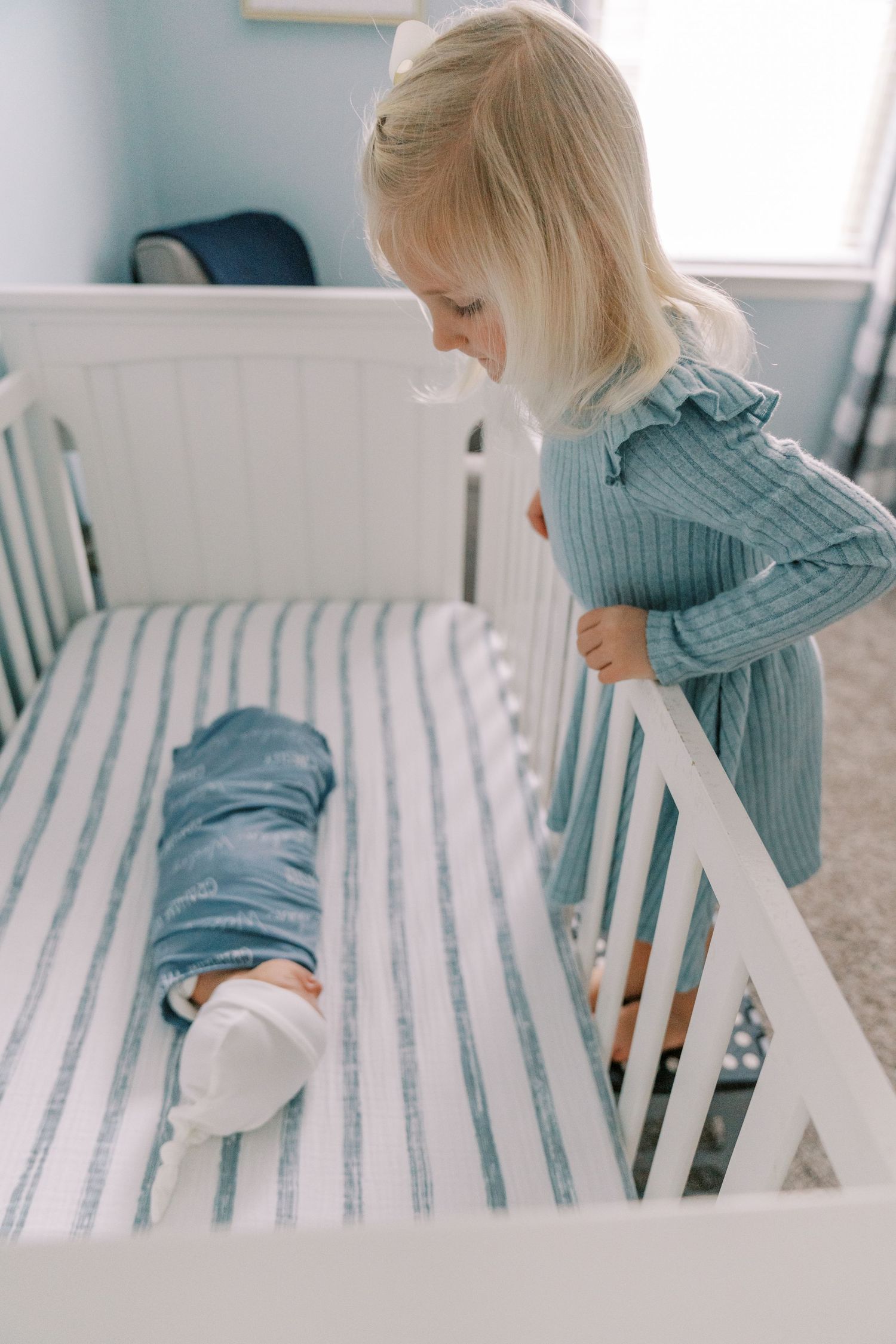 Series of images showing small child climbing onto striped bedding in nursery or bedroom.