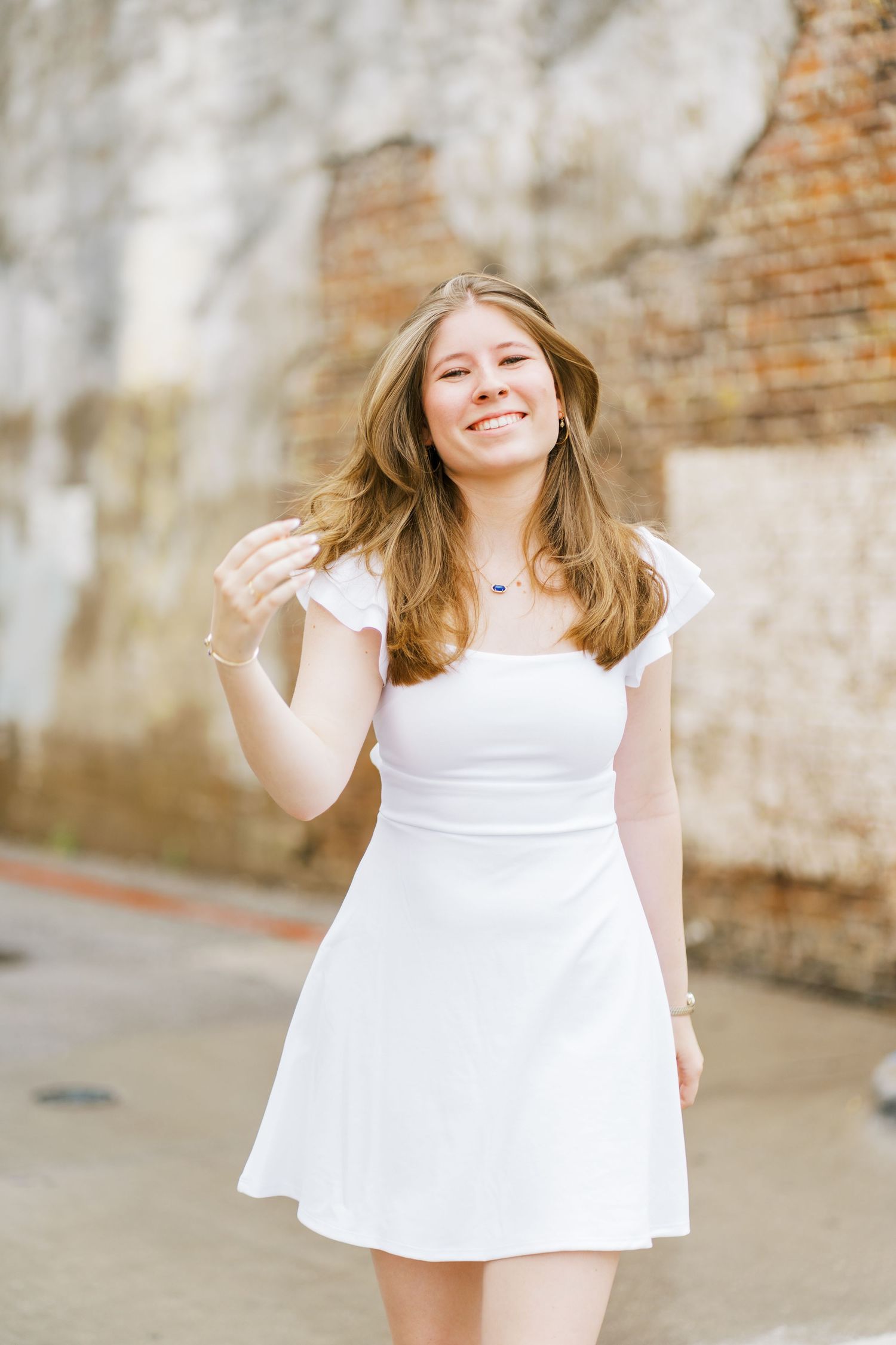 A series of joyful moments captured in white dress against a rustic brick wall background.