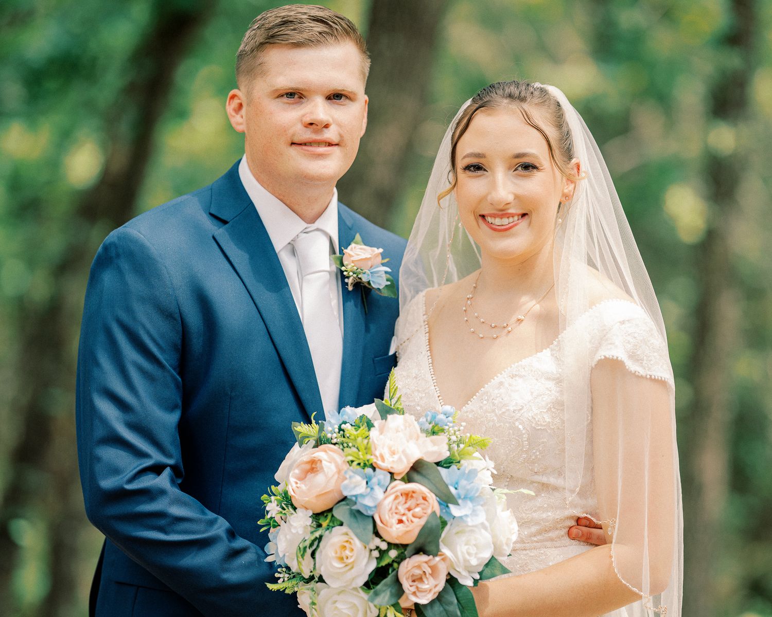 A bride and groom share intimate moments in a garden setting with soft natural lighting and peach floral bouquet.