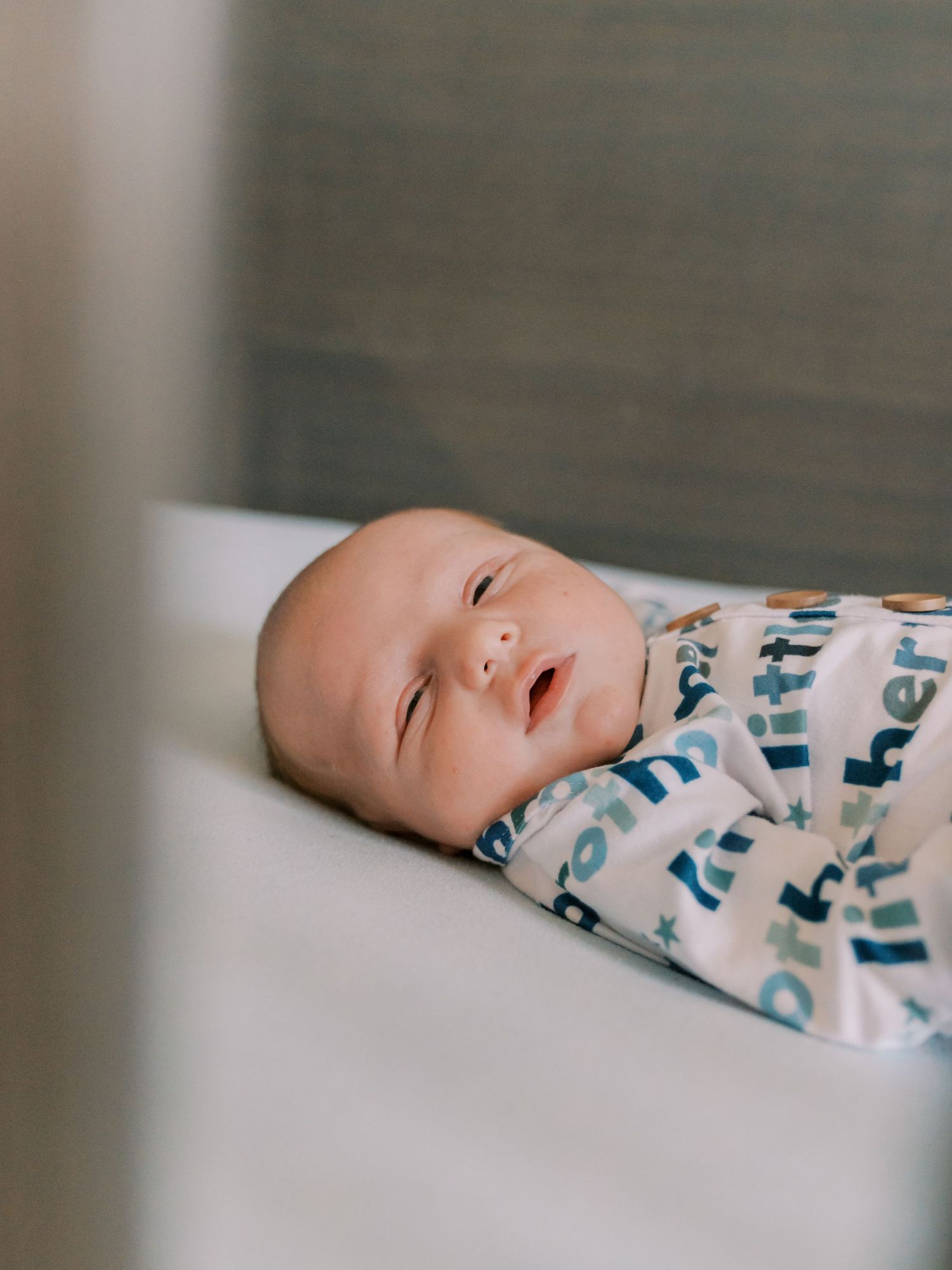 A sleeping infant rests peacefully on white bedding in a sequence of close-up profile shots.