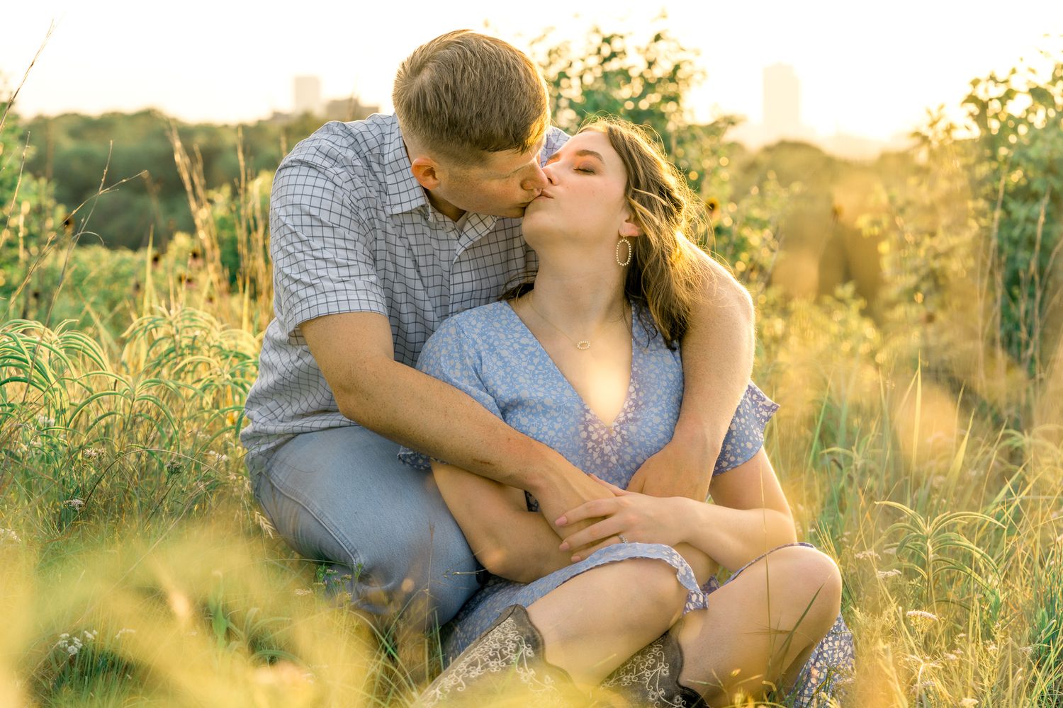 A romantic couple sharing an intimate moment in a sunlit meadow during golden hour.