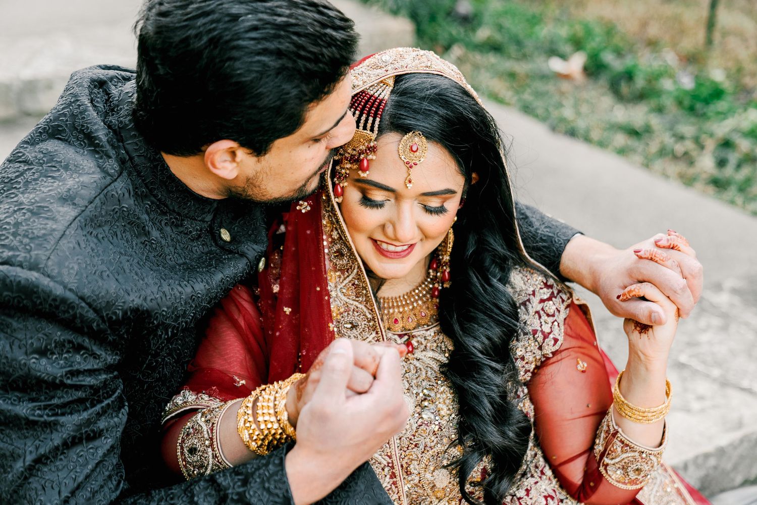 Candid moments of a couple in traditional Indian wedding outfits sharing laughter together.
