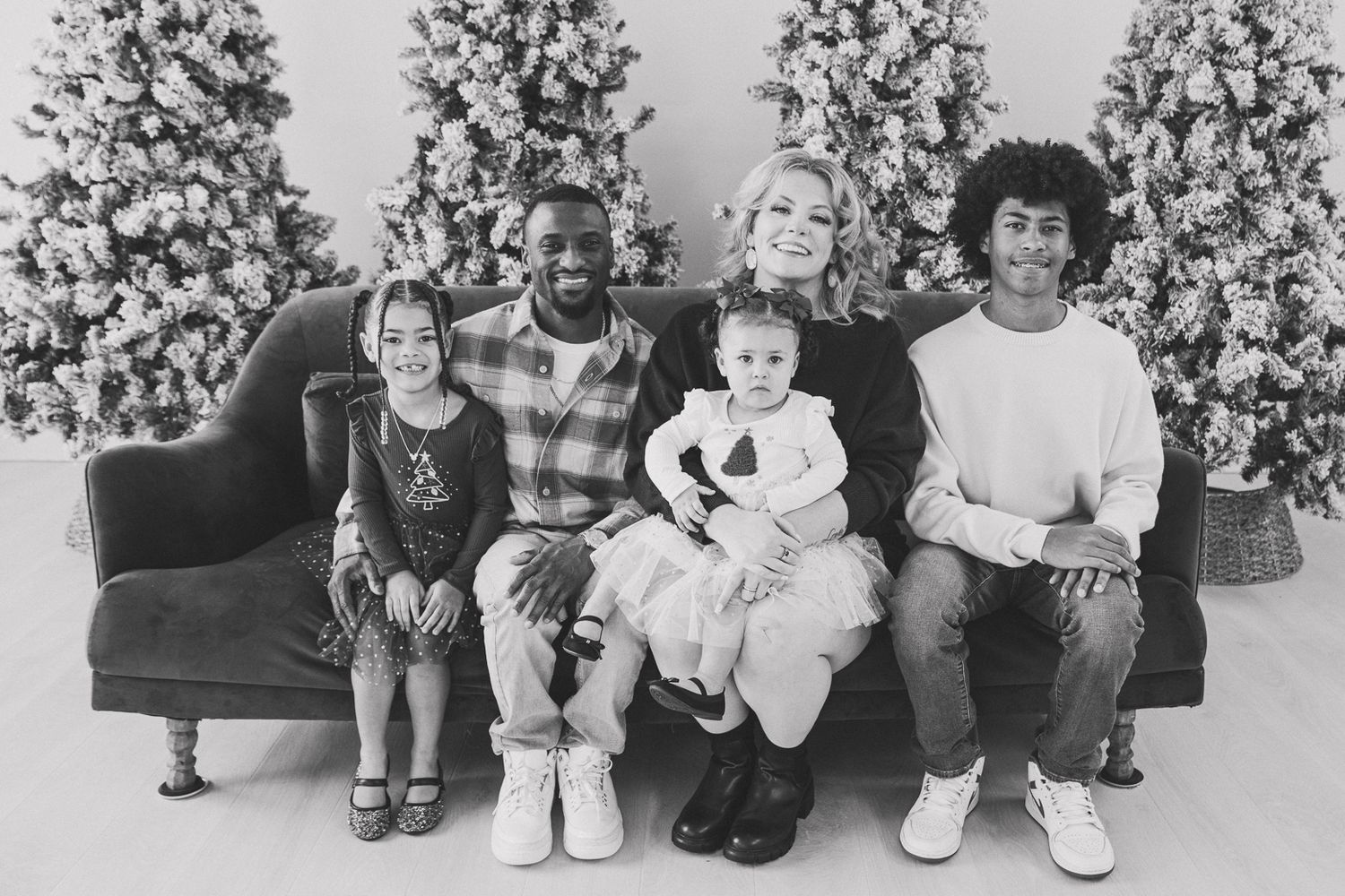 A black and white series of photos showing children seated on a couch with decorated Christmas trees behind them.