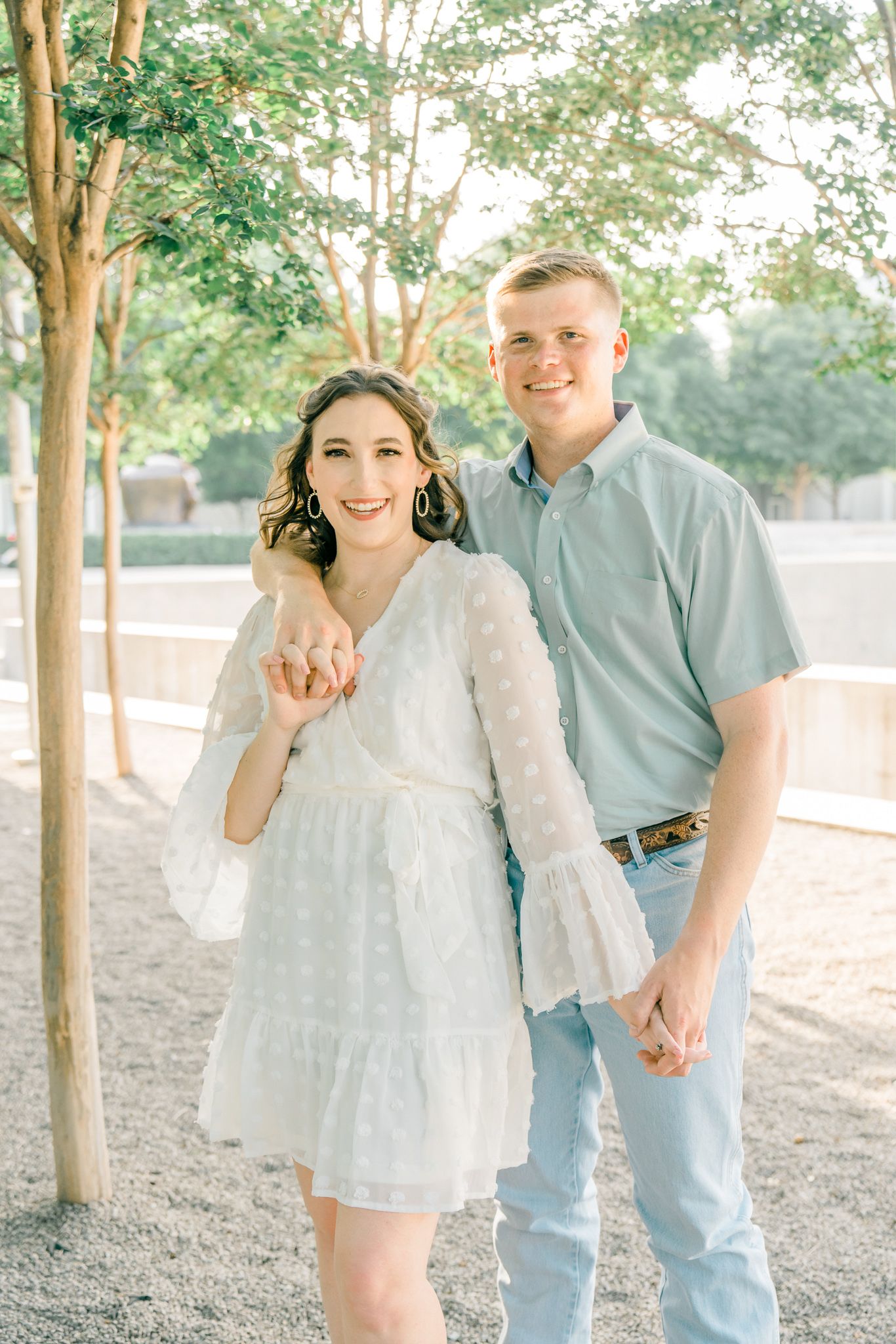 A couple shares joyful moments in coordinated blue and white outfits during an outdoor photo session.