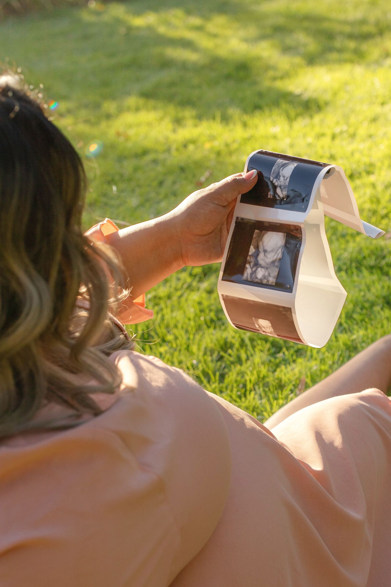 A series of photos showing hands opening a wooden box in sunlit grass.