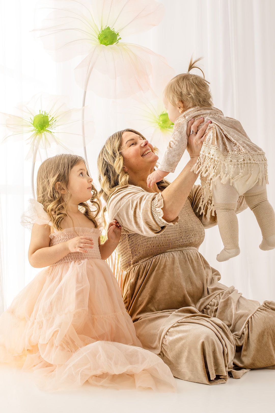 Playful sequence of parent and child in soft pink and beige tones playing with green toys against white backdrop.