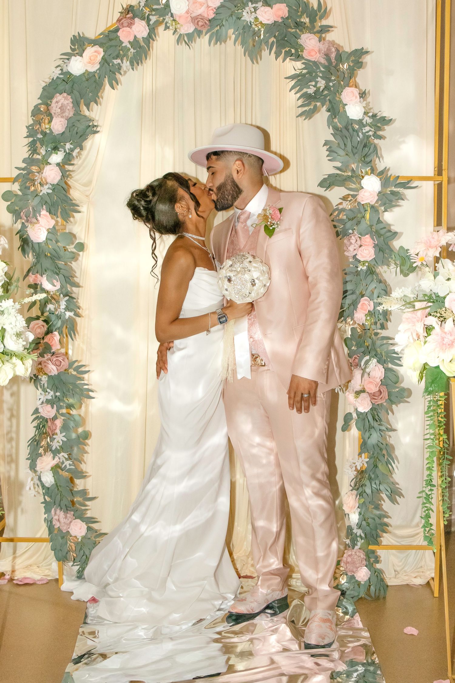 Wedding sequence showing couple in white dress and pink suit against floral backdrop.