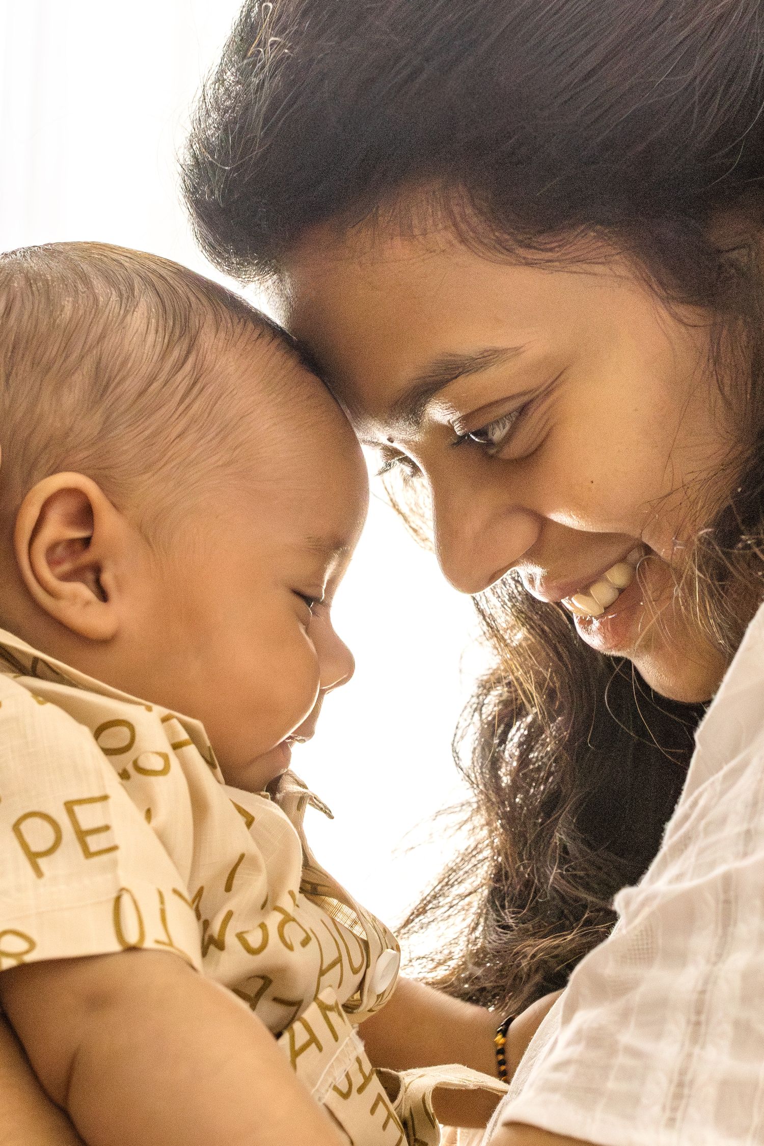 A tender moment captured in warm lighting shows a close embrace between parent and child.