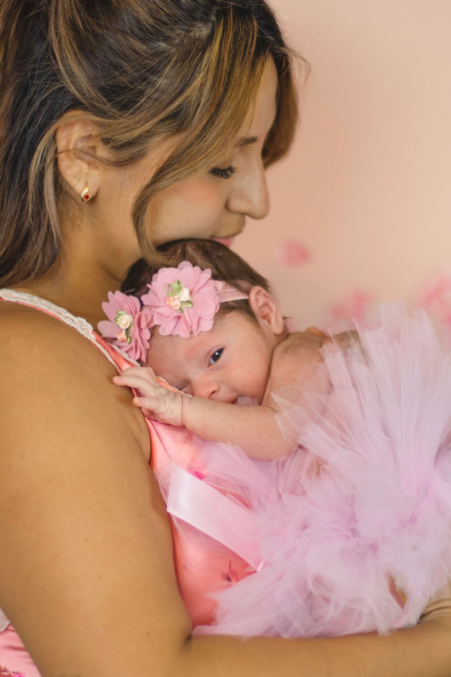 Tender moment with baby in pink tulle and floral headband.
