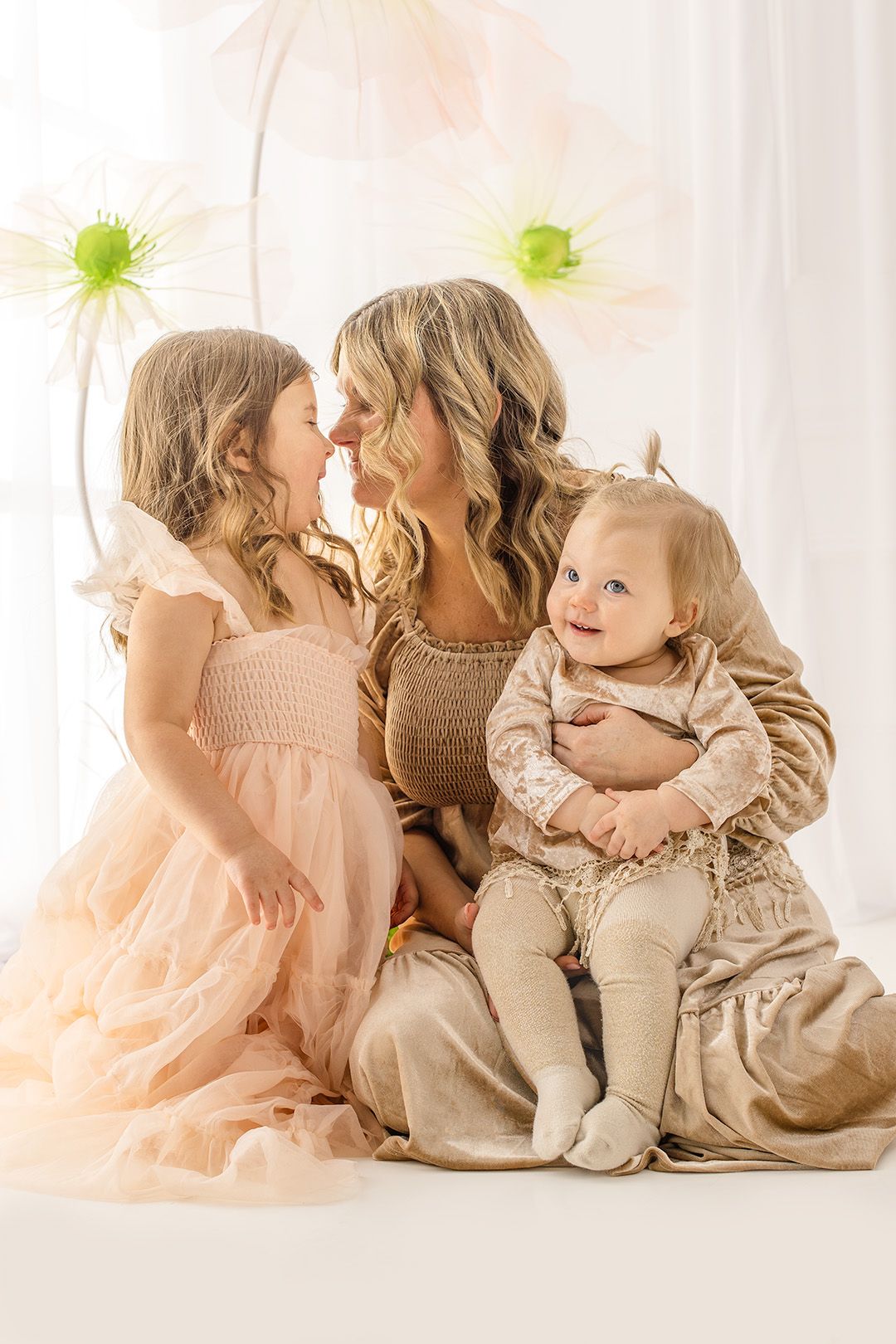 Sweet studio portrait series showing tender moments between mother and child in soft neutral tones.