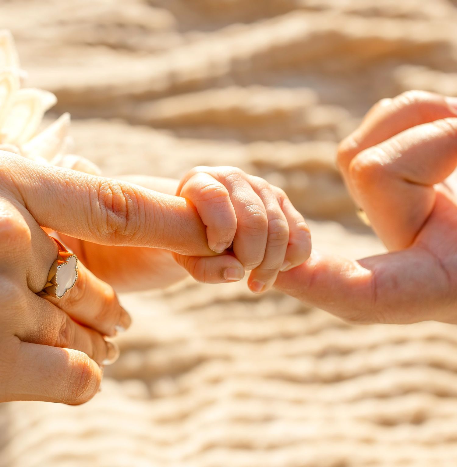Close-up sequence showing two hands exchanging a small shiny object in warm sunlight.