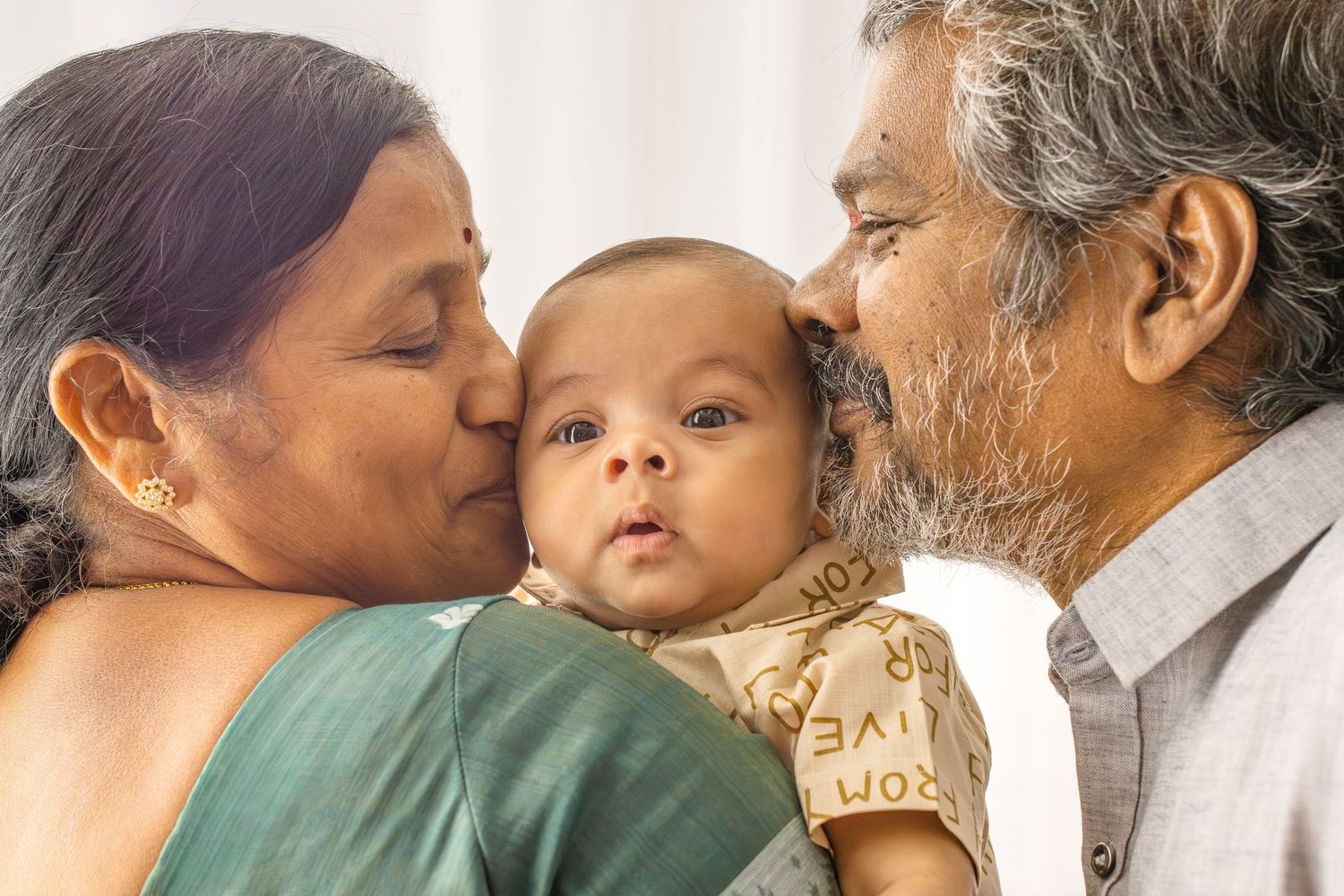 A collage of tender family moments showing multiple generations sharing kisses and embraces in warm lighting.