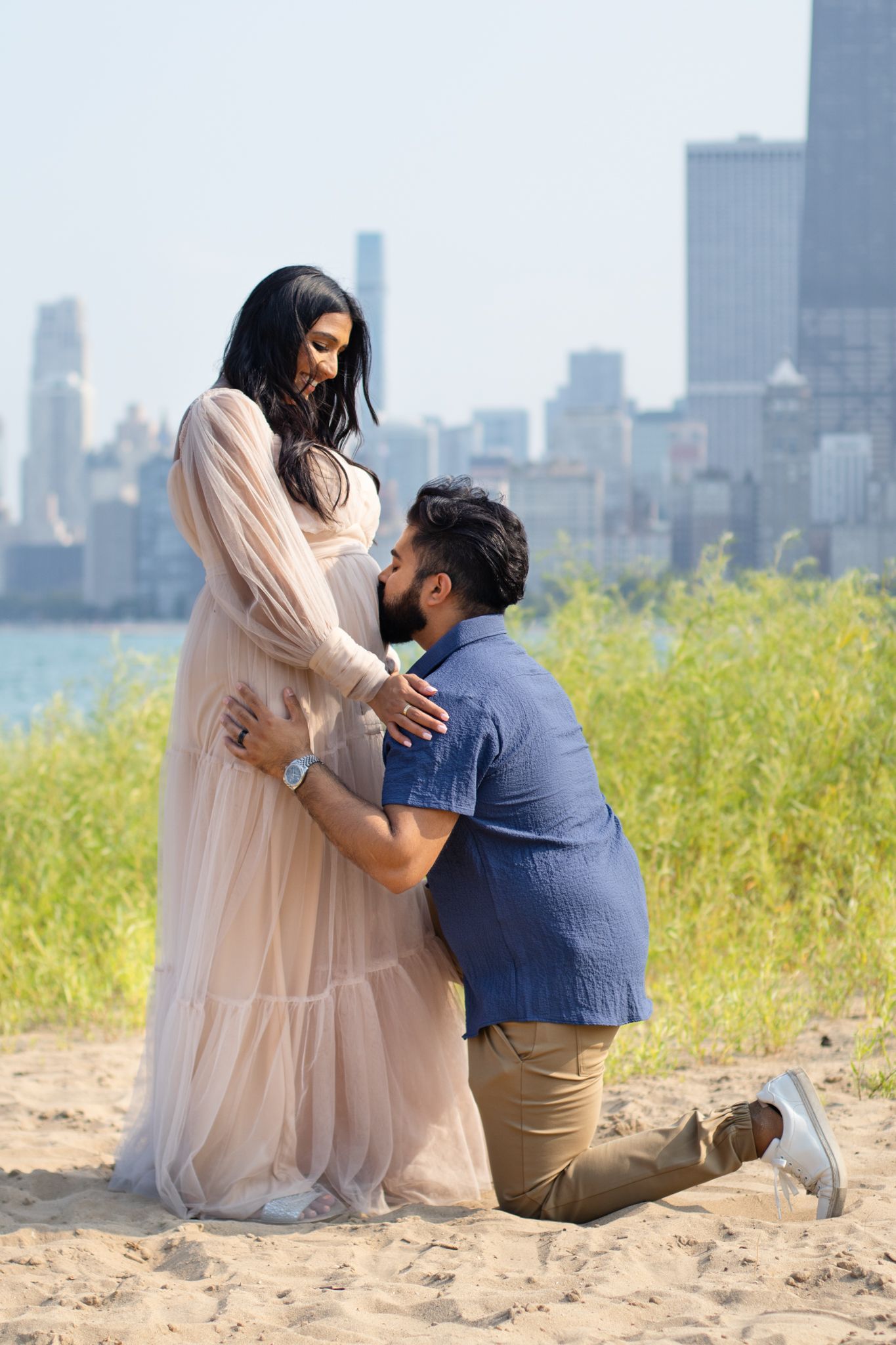 Romantic proposal moment captured on beach with Chicago's stunning skyline in background.