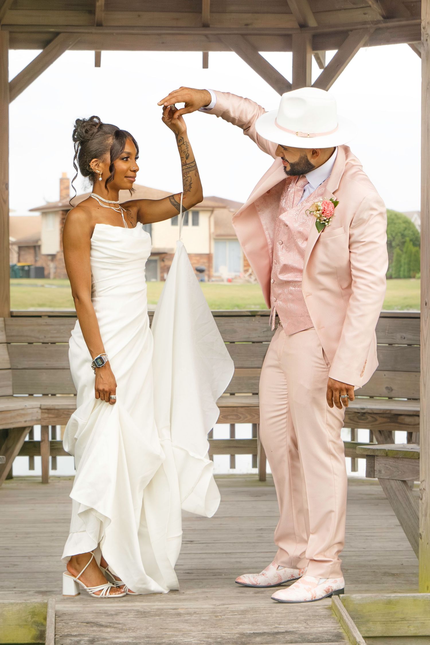 Artistic wedding dance photos showing playful movements and spins on a wooden deck.