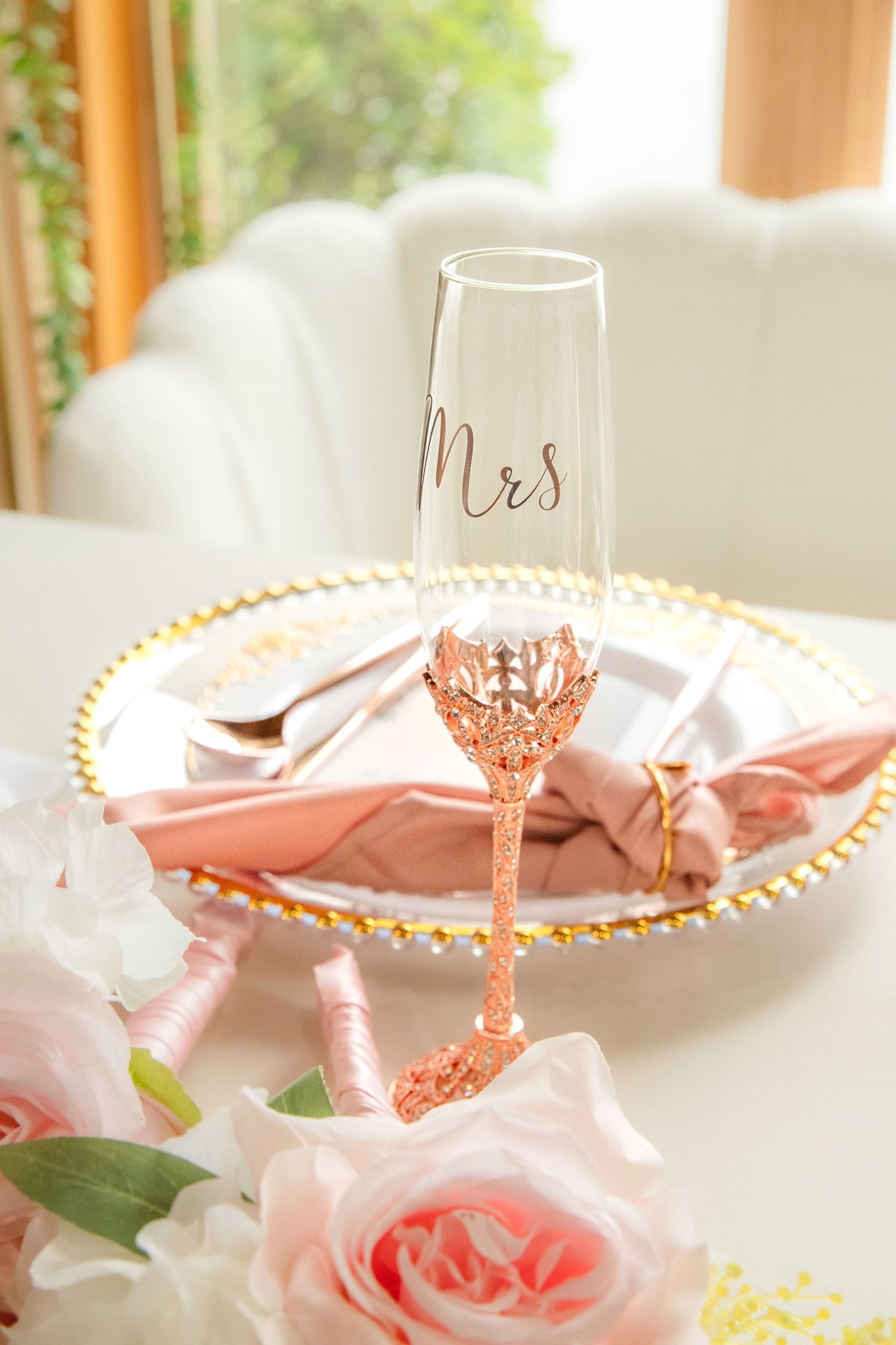 Elegant rose gold glassware and pink table decor create a romantic wedding reception tablescape.