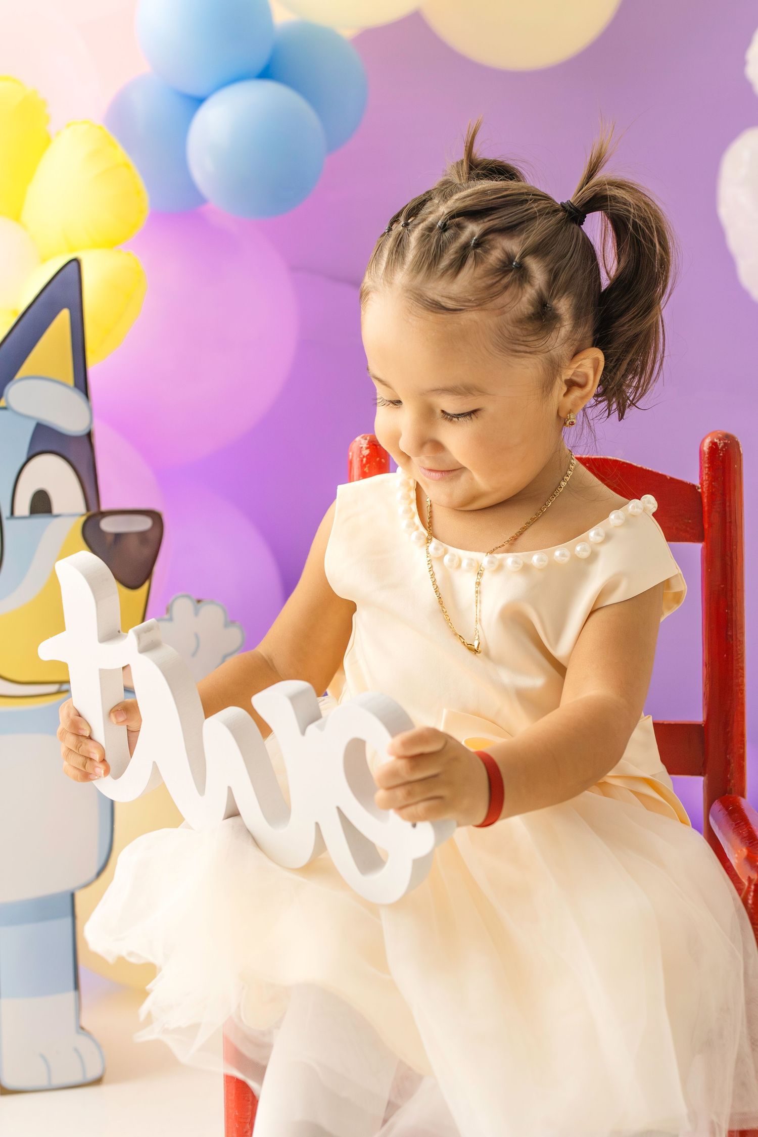 Toddler girl in white tulle dress holds a 