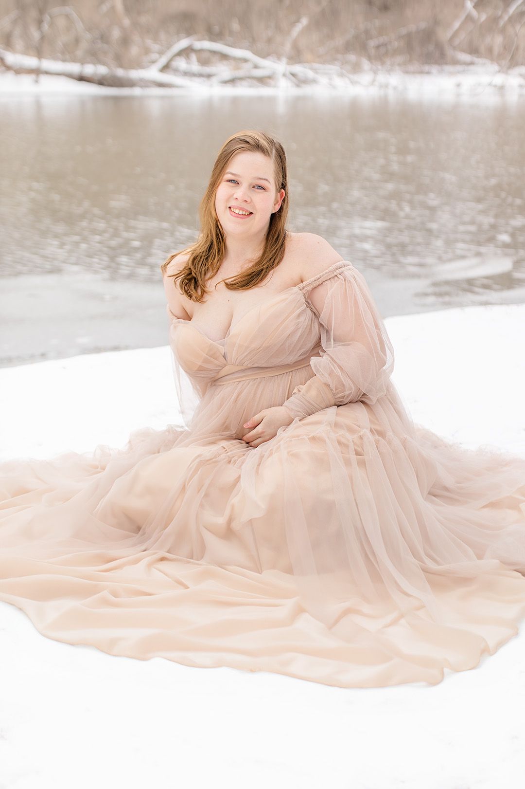 A flowing champagne-colored gown creates elegant poses in a snowy winter setting.