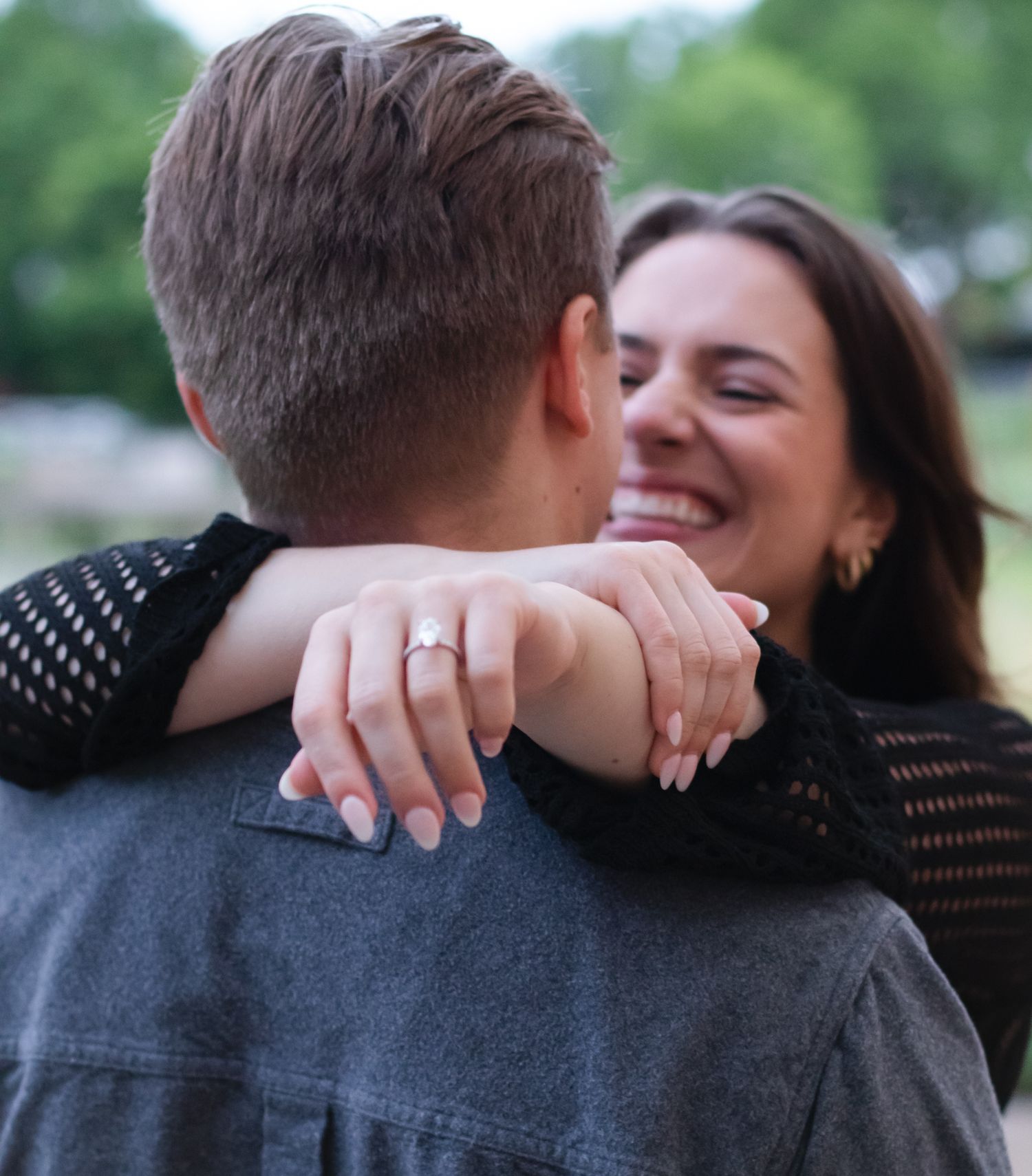 Couple embraces and laughs together during outdoor photo session.