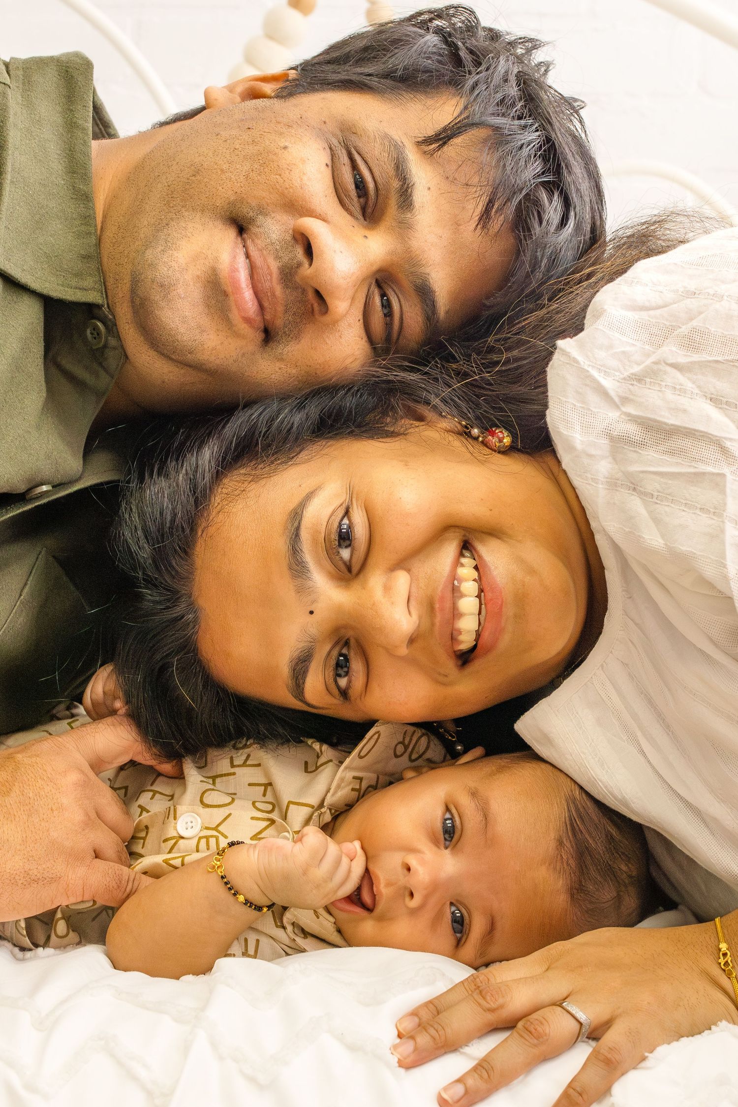 A tender moment captured showing parent and child lying down together with warm smiles.