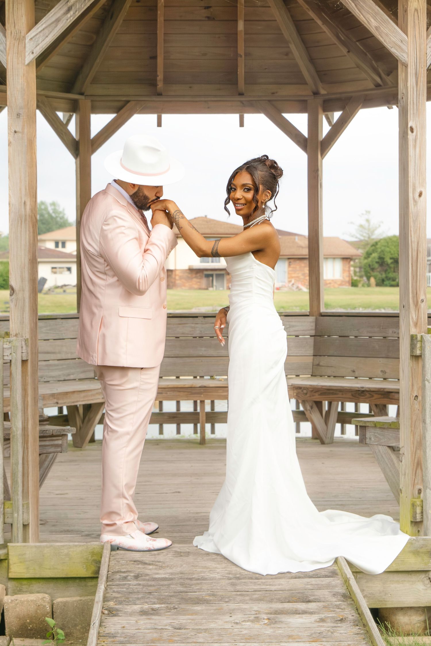 Wedding couple sharing a romantic dance moment under a rustic wooden gazebo during their special day.