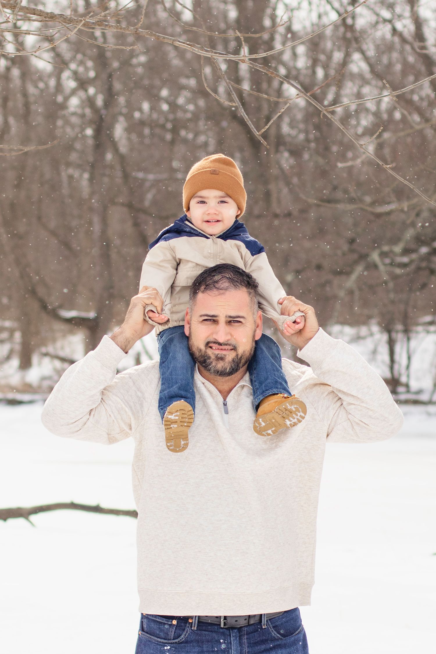 Winter family scene in snowy forest with warm clothing and playful poses.
