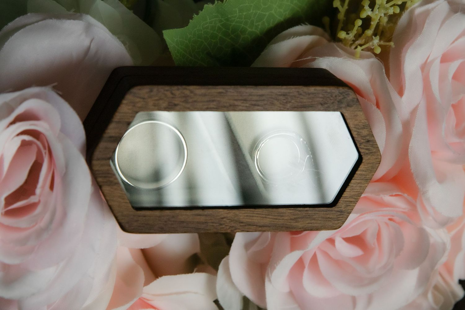 Pink roses and floral decor with rustic wood accents create an elegant table setting.
