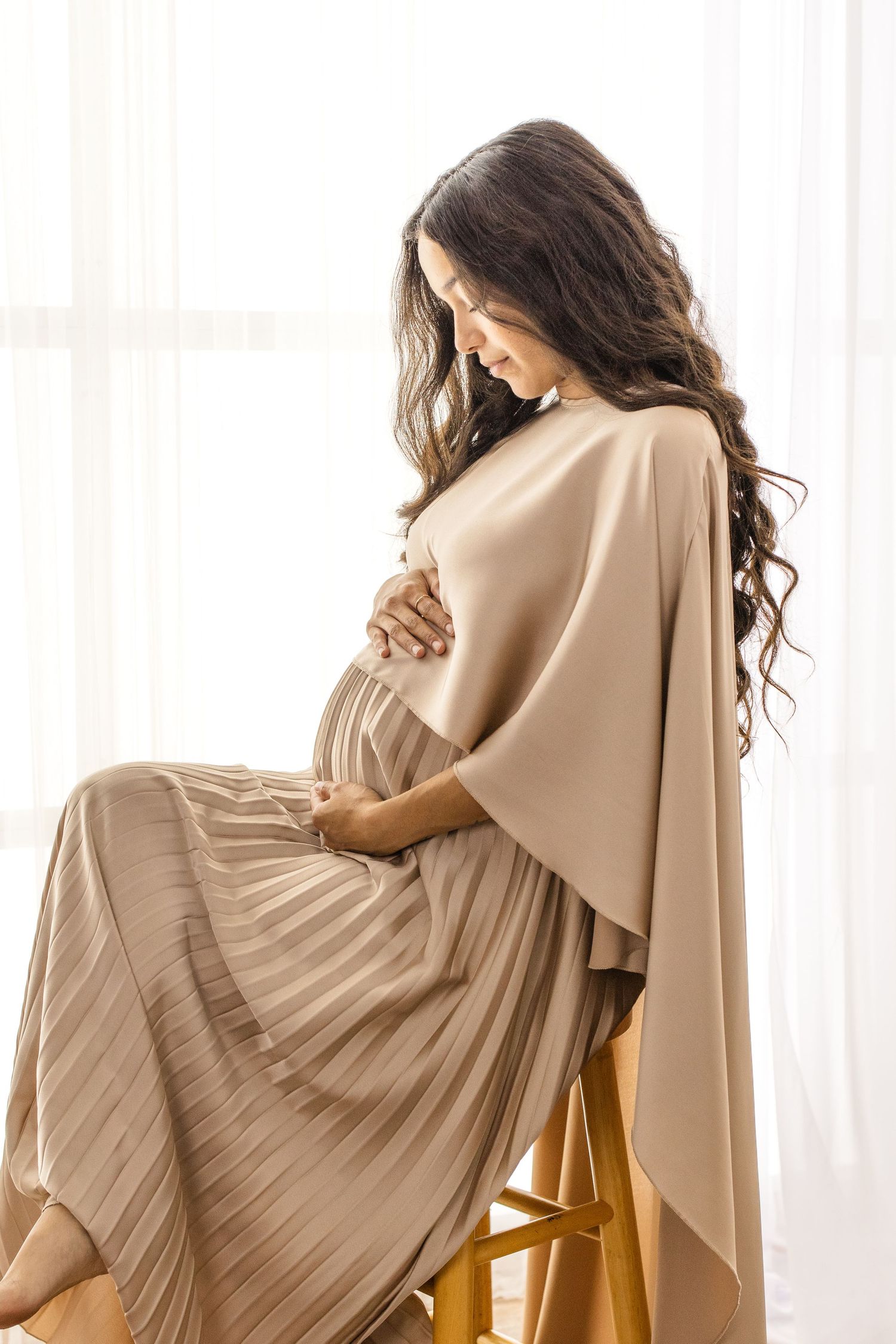 Artistic portrait series featuring draped beige fabrics and flowing hair in soft window light.