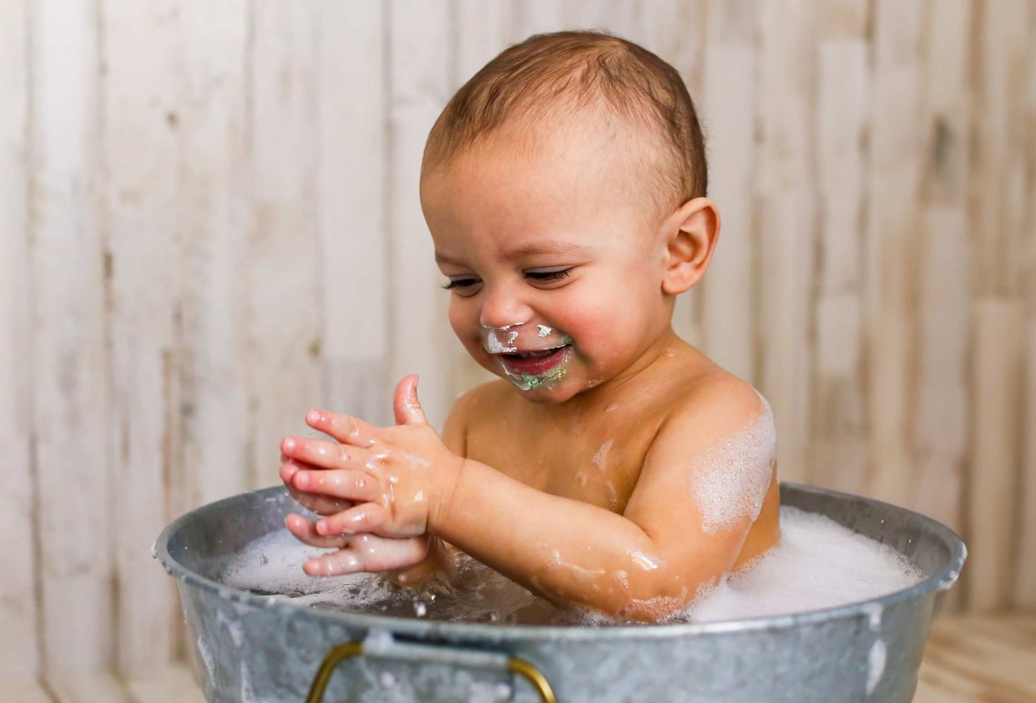 A joyful bathtime moment with splashing and laughter in a metal tub.