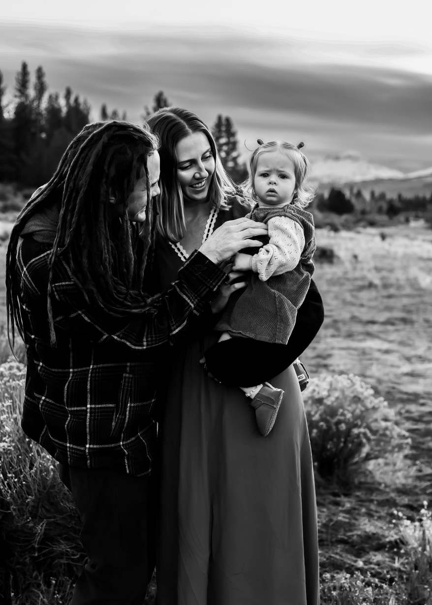 Black and white photo captures tender moments between two people in an outdoor setting.
